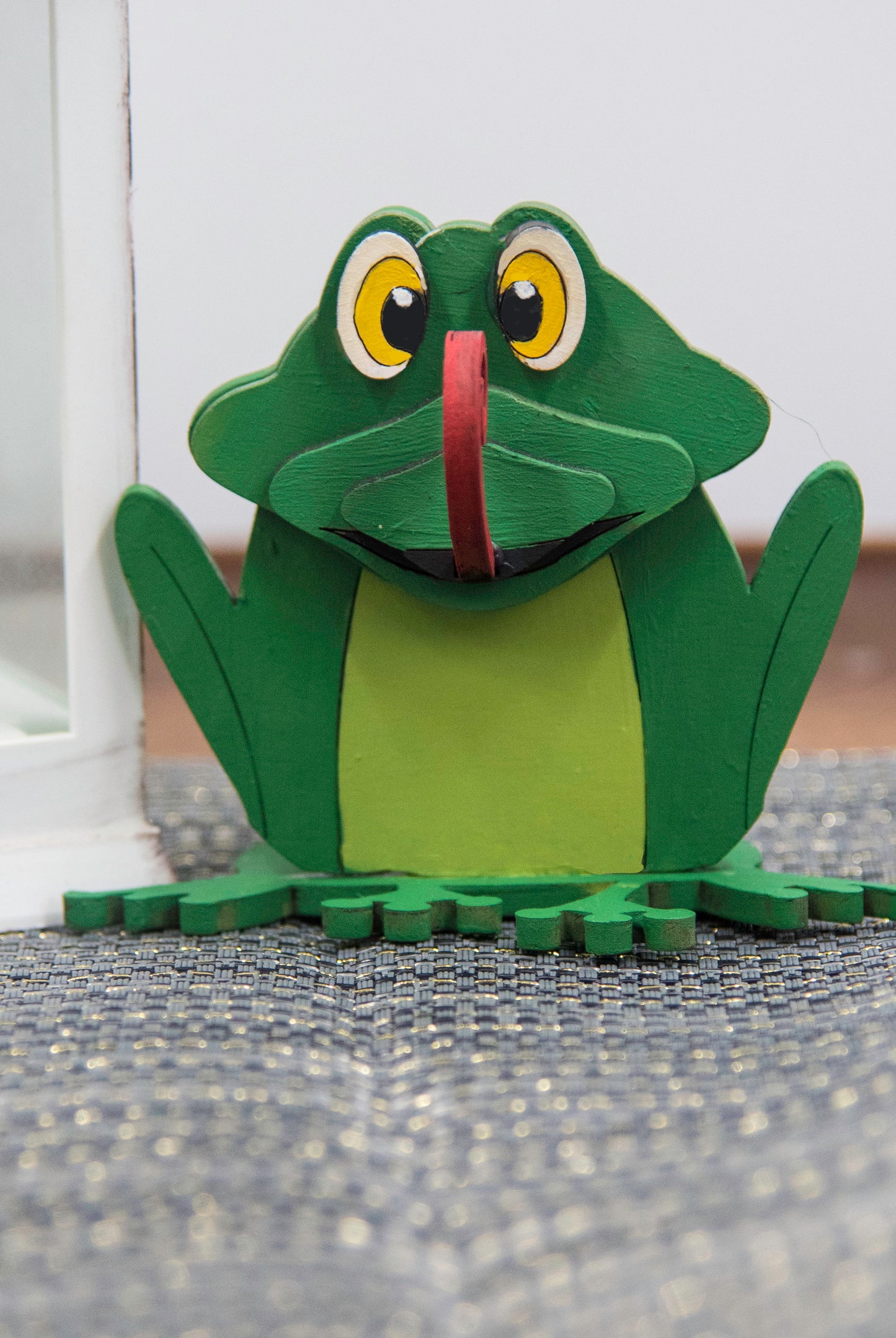Hand-painted wooden frog-shaped glasses holder with bulging eyes and a flat base to hold eyeglasses. Ideal for desks, nightstands, or gifting to frog lovers and animal fans