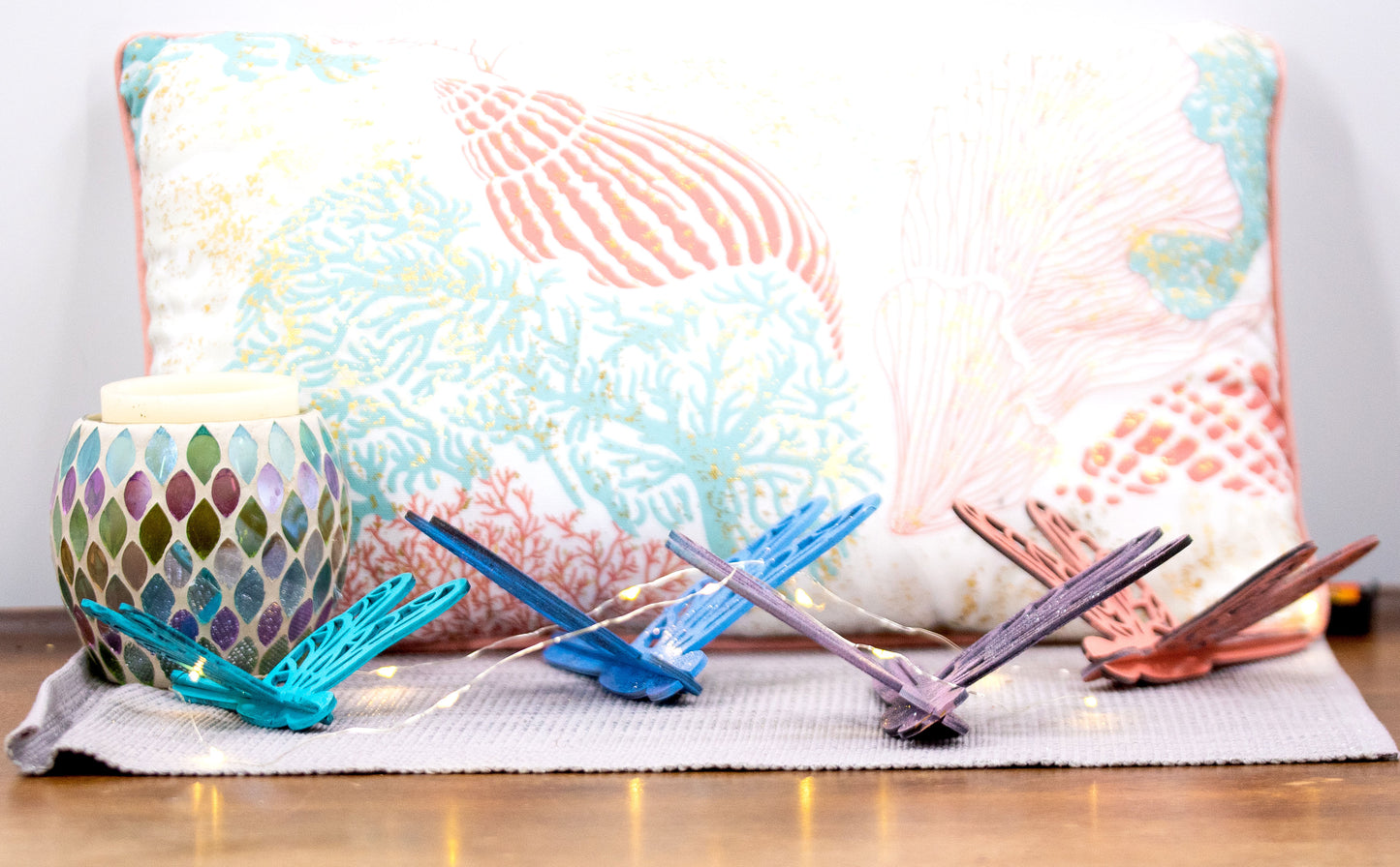 Colorful wooden dragonfly shelf sitters in rustic painted finishes, each shaped with wings and body details, perfect for whimsical spring or summer decor on mantels, shelves, or tiered trays.