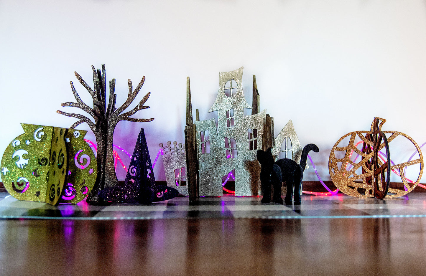Colorful 3D Halloween shelf sitters made of sliding interlocking wooden pieces, including a pumpkin, haunted house, cat, witch hat, cauldron, and tree. Painted in spooky fall tones from 3 to 7 inches tall.