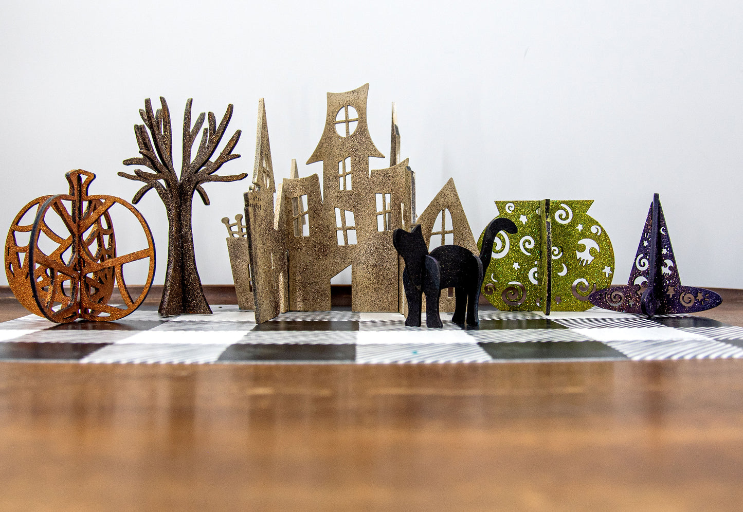Colorful 3D Halloween shelf sitters made of sliding interlocking wooden pieces, including a pumpkin, haunted house, cat, witch hat, cauldron, and tree. Painted in spooky fall tones from 3 to 7 inches tall.