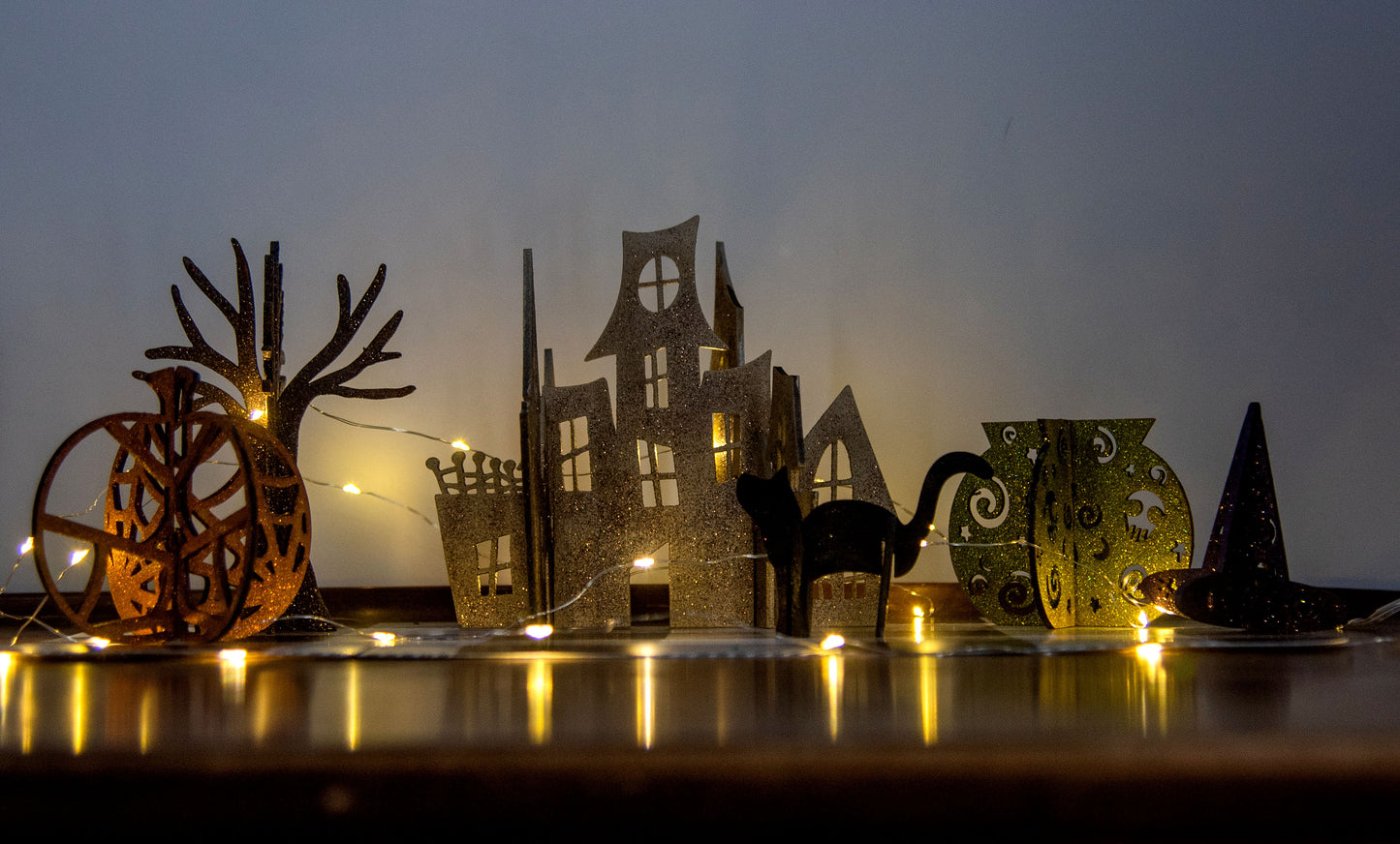 Colorful 3D Halloween shelf sitters made of sliding interlocking wooden pieces, including a pumpkin, haunted house, cat, witch hat, cauldron, and tree. Painted in spooky fall tones from 3 to 7 inches tall.