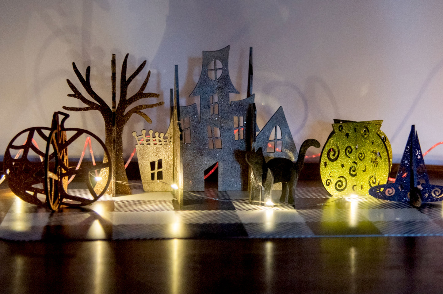 Colorful 3D Halloween shelf sitters made of sliding interlocking wooden pieces, including a pumpkin, haunted house, cat, witch hat, cauldron, and tree. Painted in spooky fall tones from 3 to 7 inches tall.