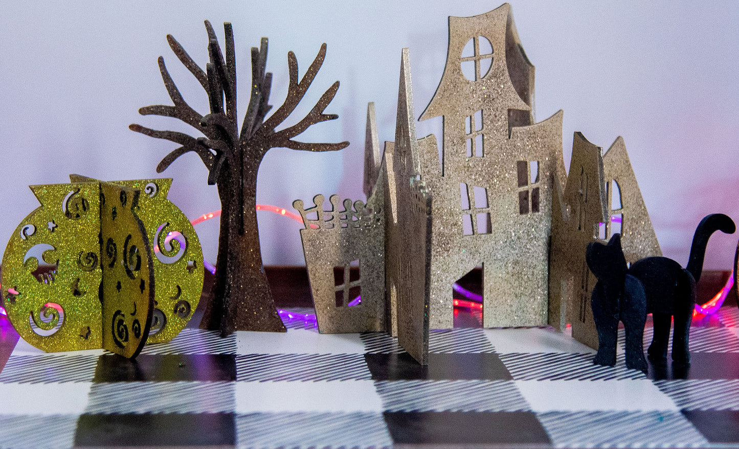 Colorful 3D Halloween shelf sitters made of sliding interlocking wooden pieces, including a pumpkin, haunted house, cat, witch hat, cauldron, and tree. Painted in spooky fall tones from 3 to 7 inches tall.