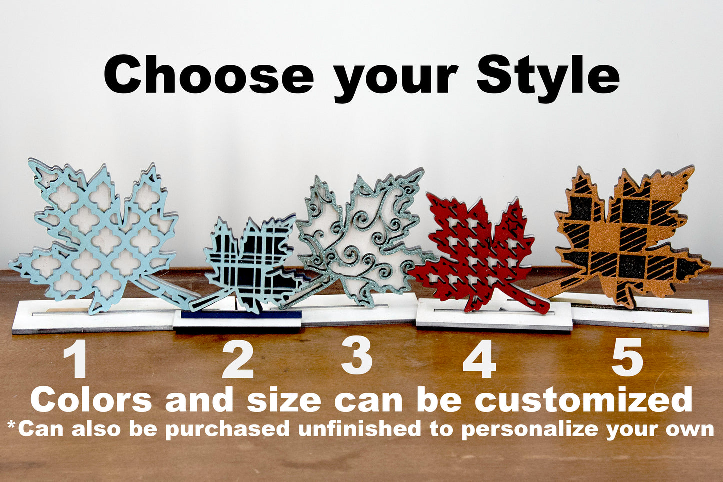 Handcrafted standing wooden leaf decor pieces in layered colors and patterns. Each leaf has a stained background with a cutout patterned top layer, sitting on a flat wood base. Ideal for fall or farmhouse-style decor