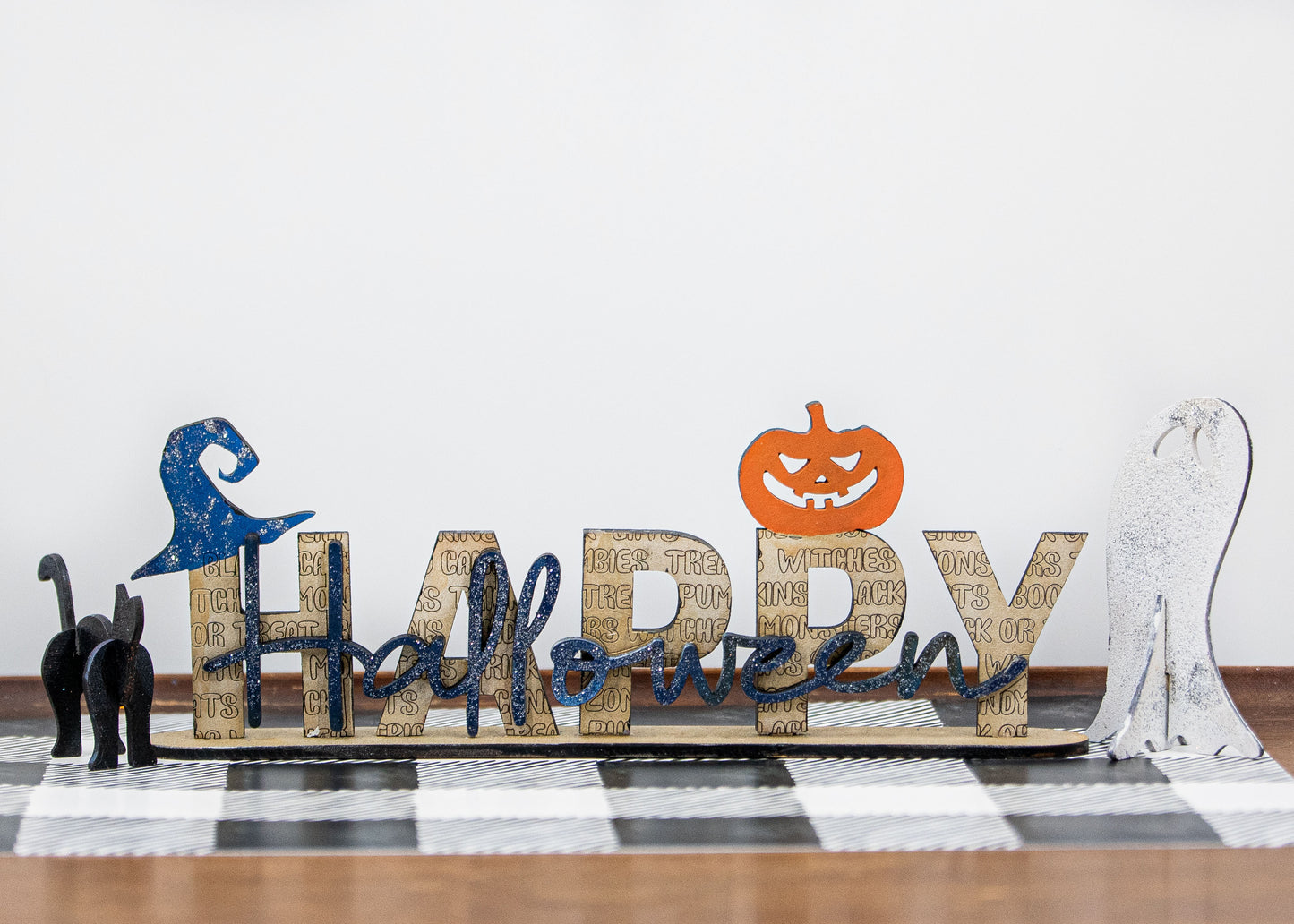 Happy Halloween wooden shelf sitter sign in festive spooky colors, laser-cut layered wood, free-standing design for mantels, shelves, or tiered tray fall decor.