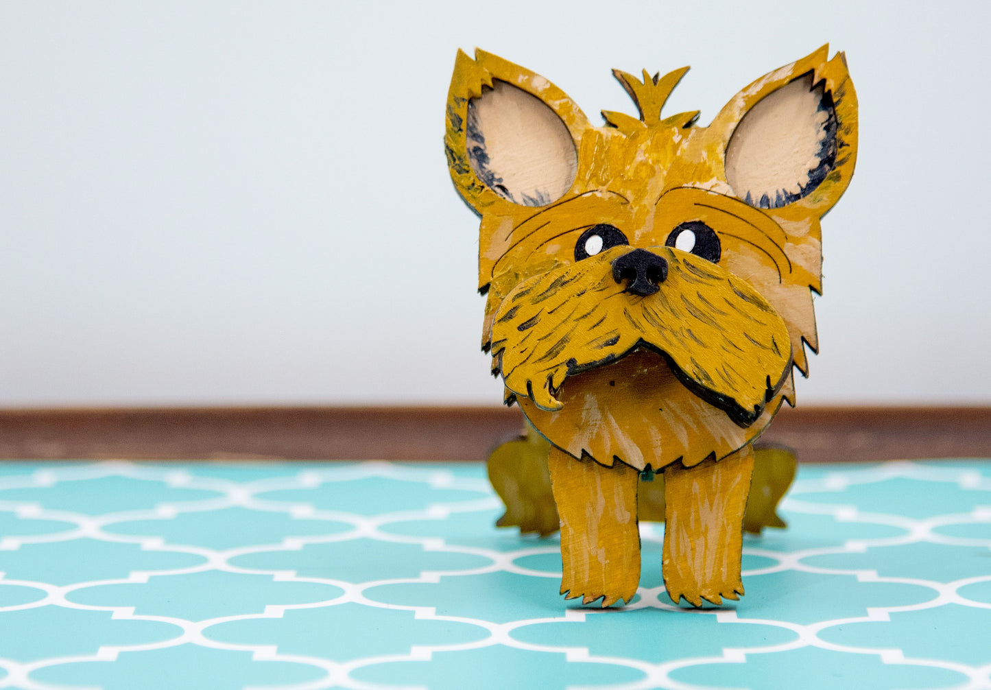 Hand-painted wooden glasses holder shaped like a Yorkshire Terrier with signature silky fur and upright ears, designed to hold eyeglasses on its face. Perfect for Yorkie lovers