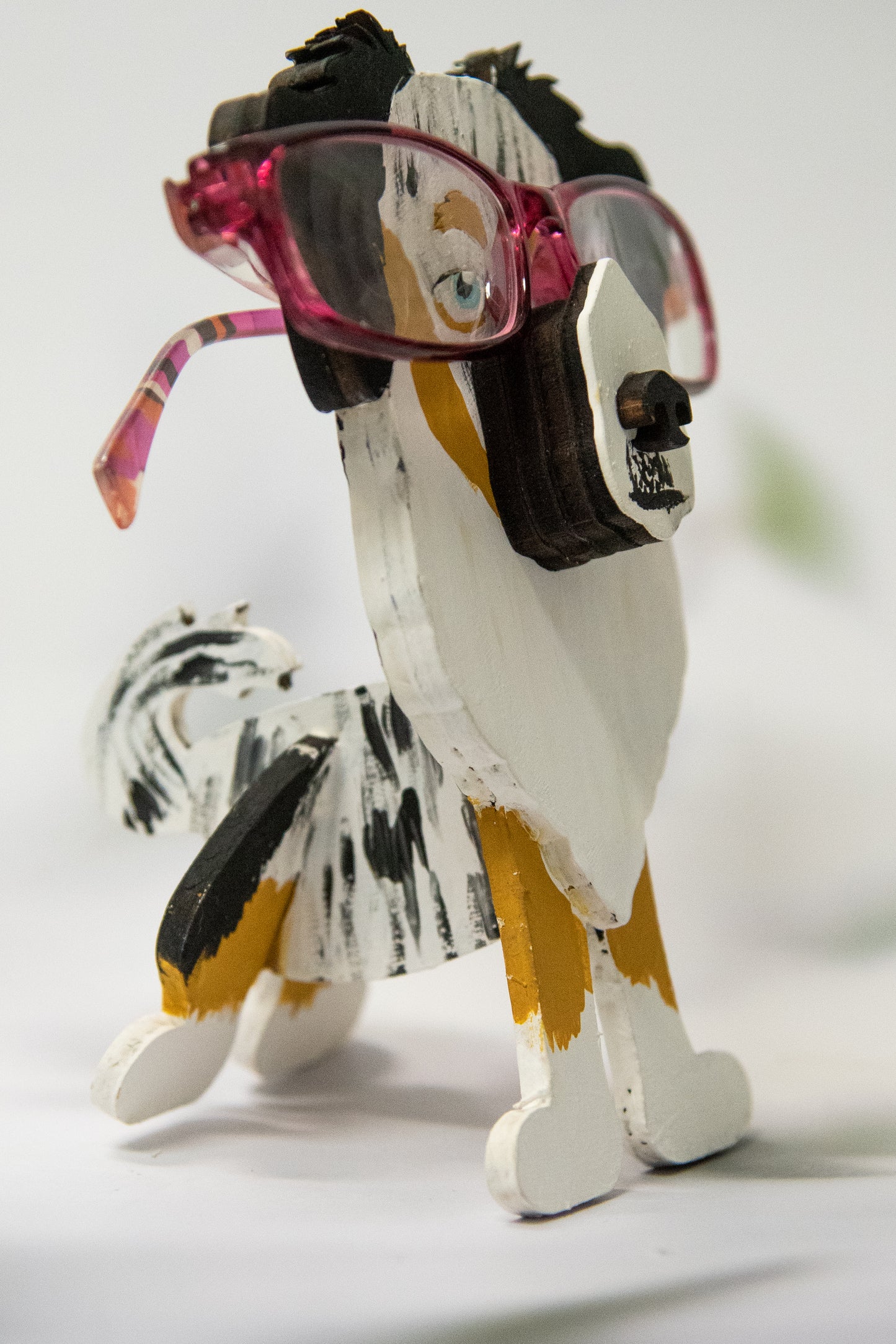 Hand-painted Australian Shepherd eyeglass holder in a sitting dog shape, available in Blue Merle, Red Merle, Black Tri, or custom colors with realistic details, designed to hold glasses on the snout. Cute and functional dog lover gift, hand-crafted and great for desks or nightstands.