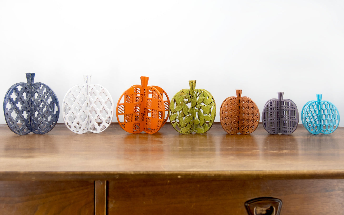 A handcrafted set of 3D wooden pumpkins designed to slot together and stand upright, perfect for Halloween or fall home decor. Each pumpkin features layered wood details and a freestanding base. Great for shelf styling, entry tables, tiered trays, or Thanksgiving centerpieces.
