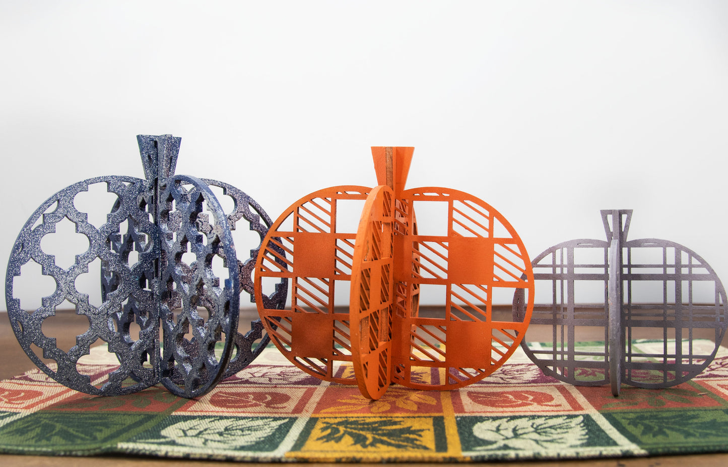 A handcrafted set of 3D wooden pumpkins designed to slot together and stand upright, perfect for Halloween or fall home decor. Each pumpkin features layered wood details and a freestanding base. Great for shelf styling, entry tables, tiered trays, or Thanksgiving centerpieces.
