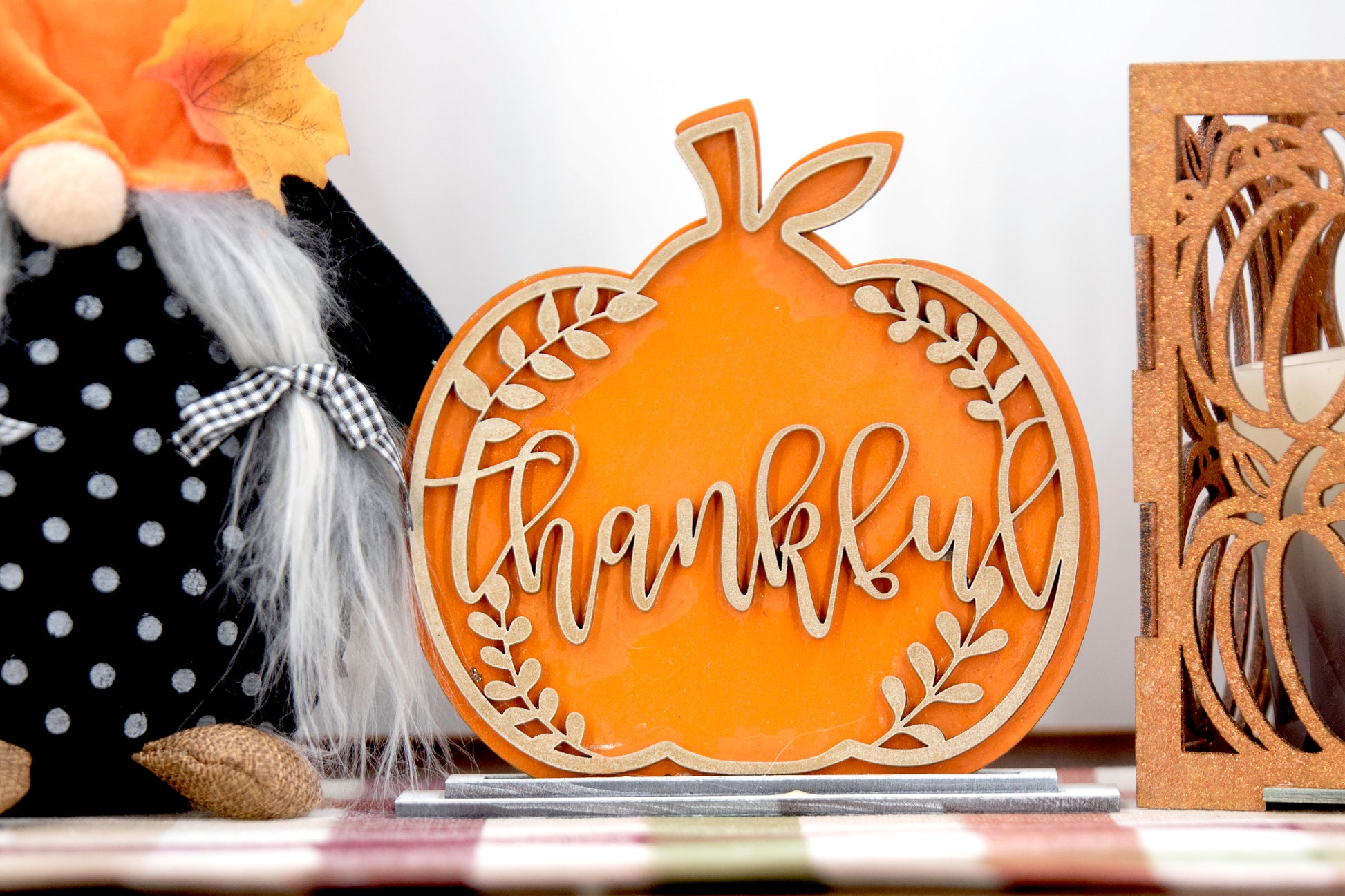 Layered standing wooden pumpkins ranging from 5.5 to 8 inches tall, featuring a solid color background and patterned top layer in assorted fall colors and rustic prints. Some designs include engraved words like 'Blessed' and 'Grateful.' Each pumpkin stands on a wooden base, making them ideal for fall shelf decor, Thanksgiving displays, or farmhouse-style seasonal arrangements.