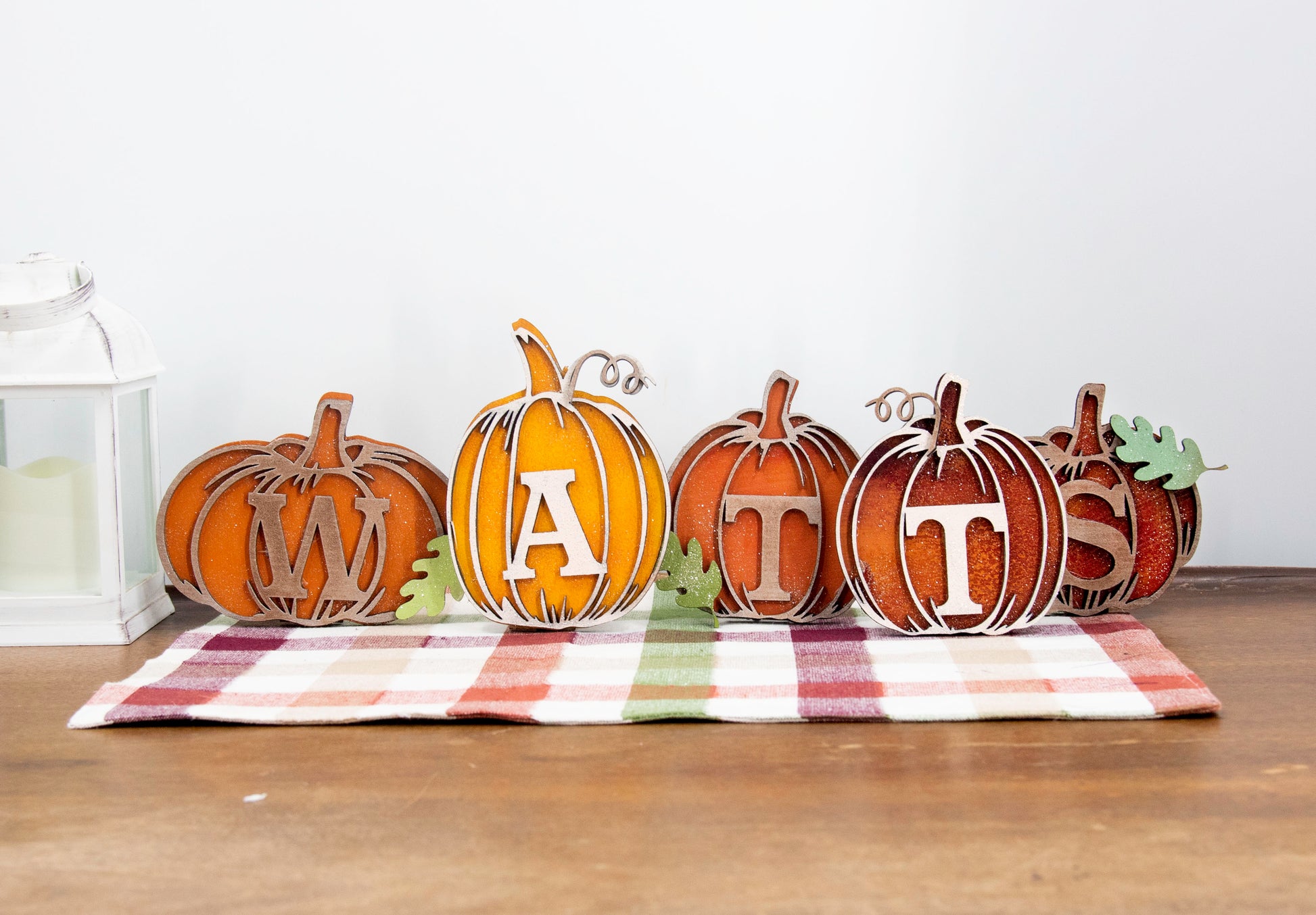 Custom standing wood pumpkins designed as individual letters to spell out names, fall words, or seasonal phrases. Each letter is crafted into a 3D pumpkin shape with intricate etched details, layered for dimension, and hand-painted in your choice of autumn colors. These personalized shelf sitters range in size from 3 to 6.5 inches and are perfect for mantels, entry tables, tiered trays, classrooms, or Thanksgiving displays. Ideal for gifting or adding a festive touch to your home.
