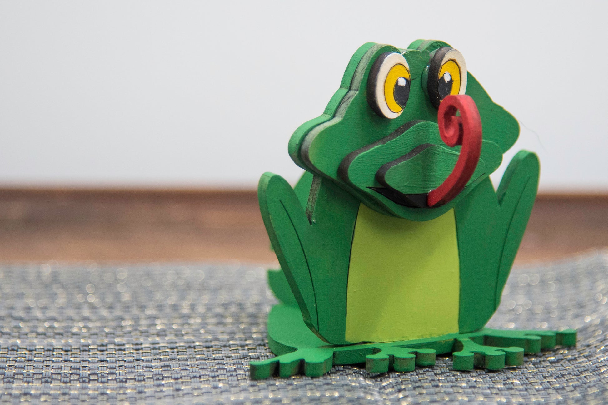 Hand-painted wooden frog-shaped glasses holder with bulging eyes and a flat base to hold eyeglasses. Ideal for desks, nightstands, or gifting to frog lovers and animal fans