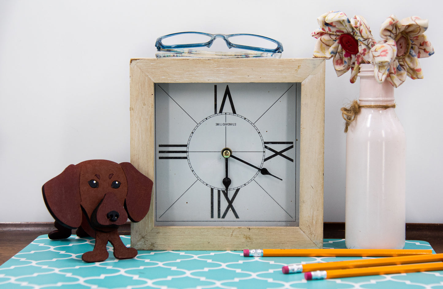 Handcrafted small wooden glasses holder in the shape of a Dachshund, featuring a painted dog design with carved detail and a curved snout to hold eyeglasses securely. A compact and charming gift for dog lovers, especially fans of wiener dogs, and perfect for display on a nightstand, office desk, or bookshelf.