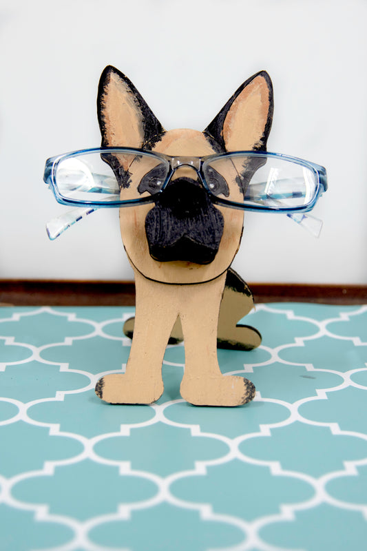 Handmade wooden German Shepherd glasses holder, crafted with carved facial details and a secure snout-shaped rest for eyeglasses. Finished in rustic paint tones with optional personalization, this dog-shaped stand is both a charming gift and a functional decor piece for pet lovers, especially German Shepherd owners. Ideal for desks, nightstands, or entry tables.