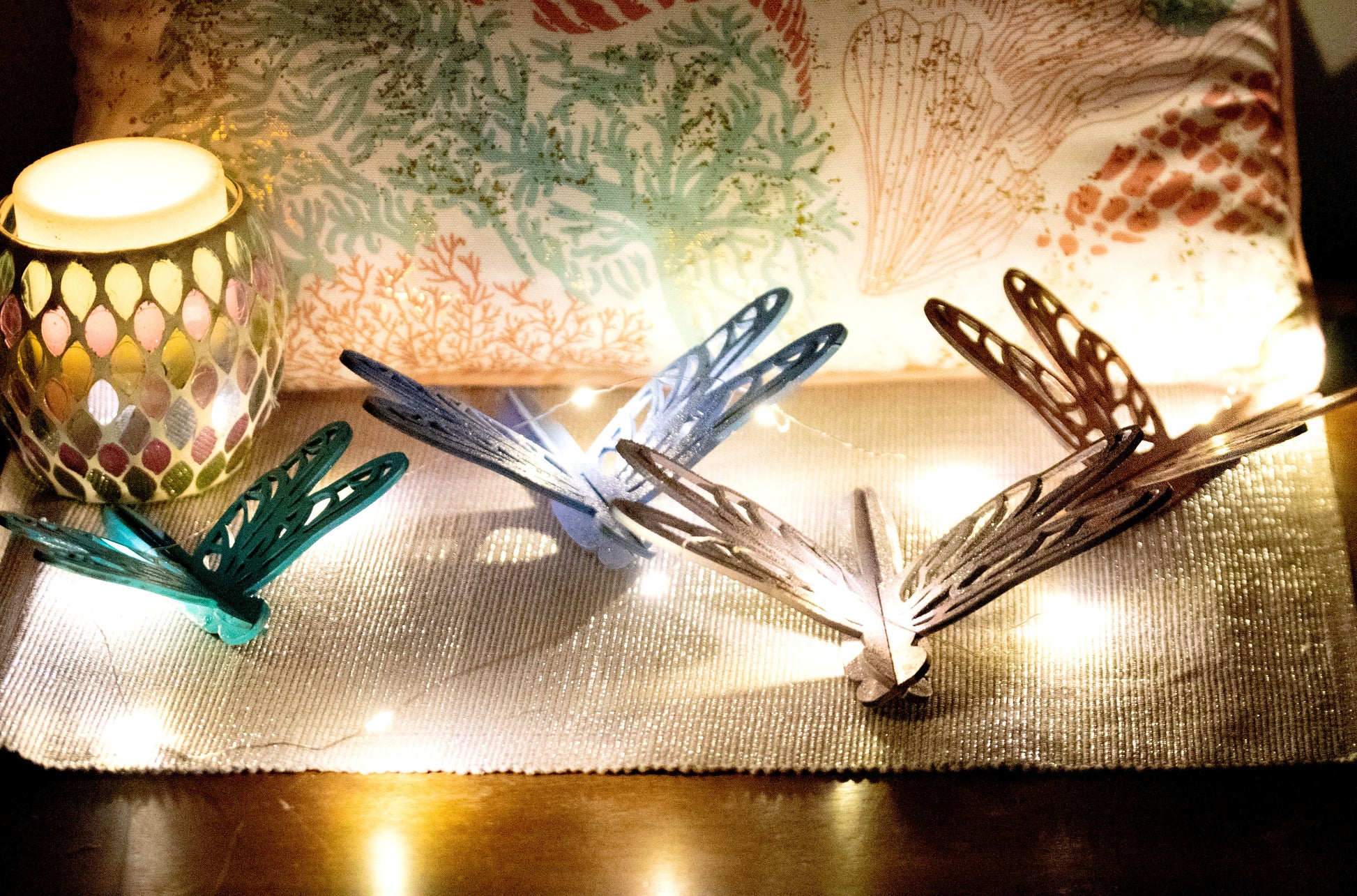 Colorful wooden dragonfly shelf sitters in rustic painted finishes, each shaped with wings and body details, perfect for whimsical spring or summer decor on mantels, shelves, or tiered trays.