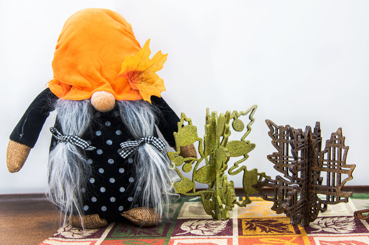 Freestanding 3D wooden leaf shelf sitters crafted with an interlocking two-piece design, painted in warm autumn colors such as orange, red, yellow, and brown. Each leaf features intricate engraved patterns and textures, making them perfect for seasonal tiered trays, mantels, or fall-themed centerpieces. Sizes range from 3 to 5.5 inches tall, with customizable color options for a unique, rustic autumn decor touch.
