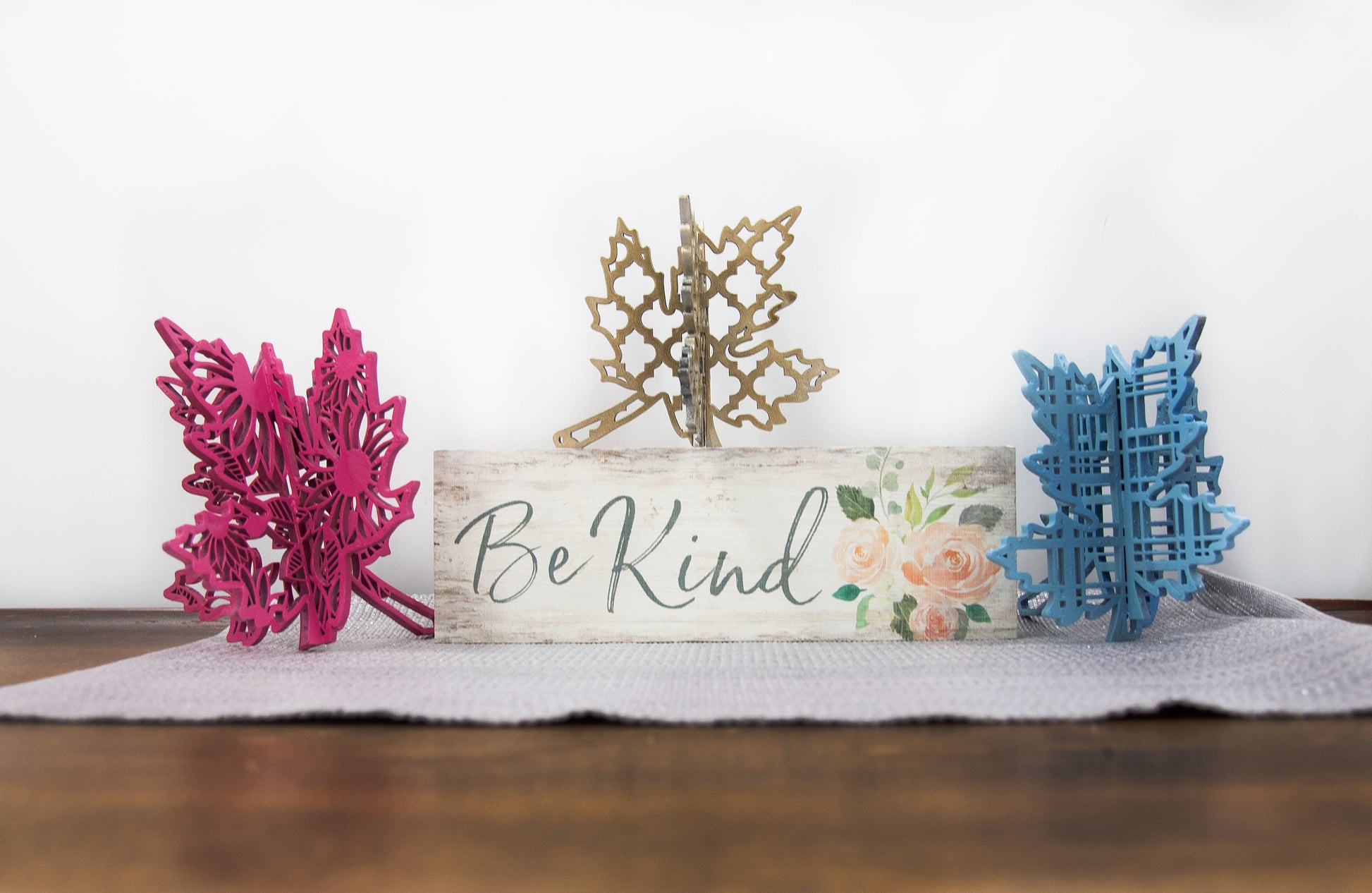 Freestanding 3D wooden leaf shelf sitters crafted with an interlocking two-piece design, painted in warm autumn colors such as orange, red, yellow, and brown. Each leaf features intricate engraved patterns and textures, making them perfect for seasonal tiered trays, mantels, or fall-themed centerpieces. Sizes range from 3 to 5.5 inches tall, with customizable color options for a unique, rustic autumn decor touch.
