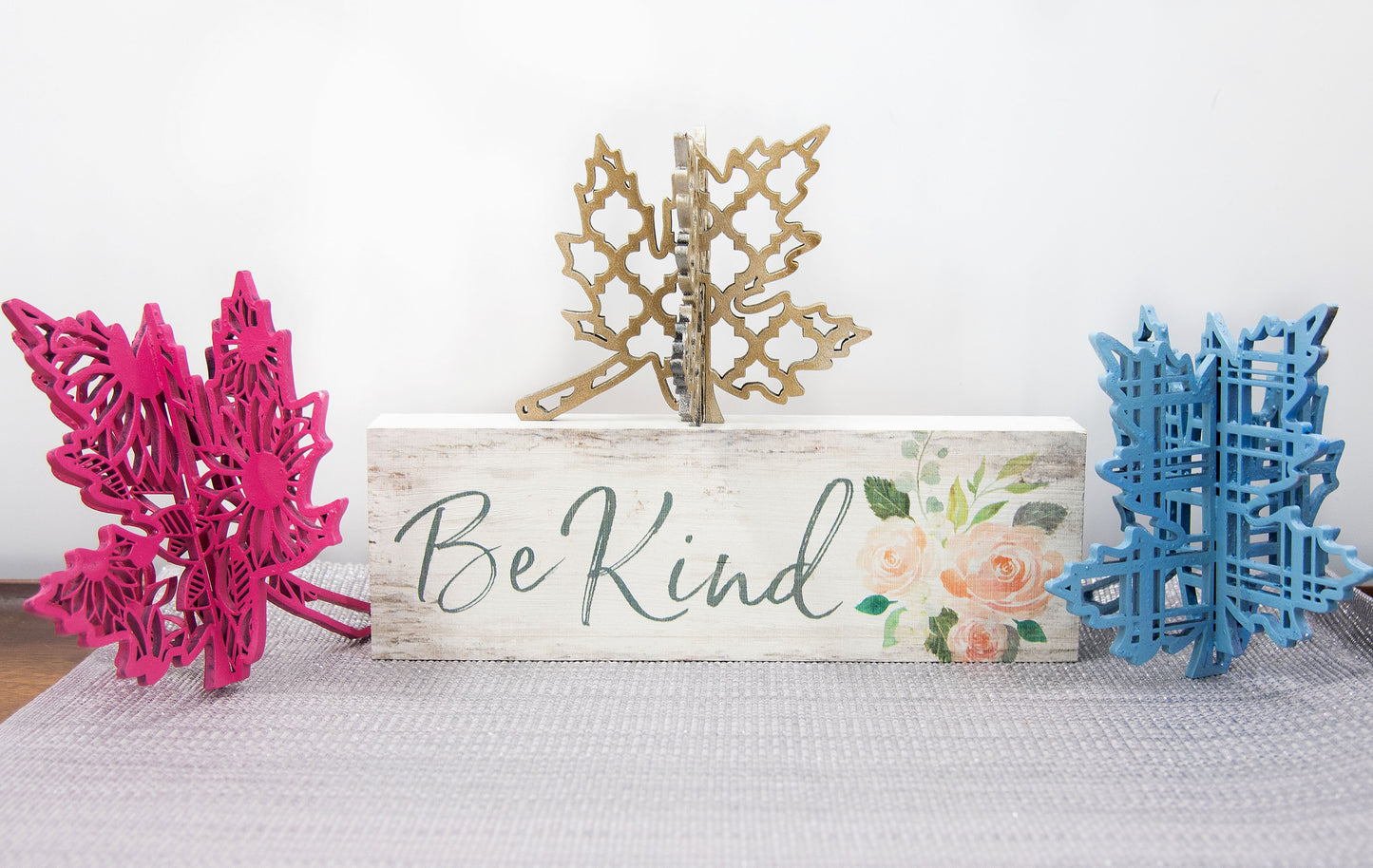 Freestanding 3D wooden leaf shelf sitters crafted with an interlocking two-piece design, painted in warm autumn colors such as orange, red, yellow, and brown. Each leaf features intricate engraved patterns and textures, making them perfect for seasonal tiered trays, mantels, or fall-themed centerpieces. Sizes range from 3 to 5.5 inches tall, with customizable color options for a unique, rustic autumn decor touch.
