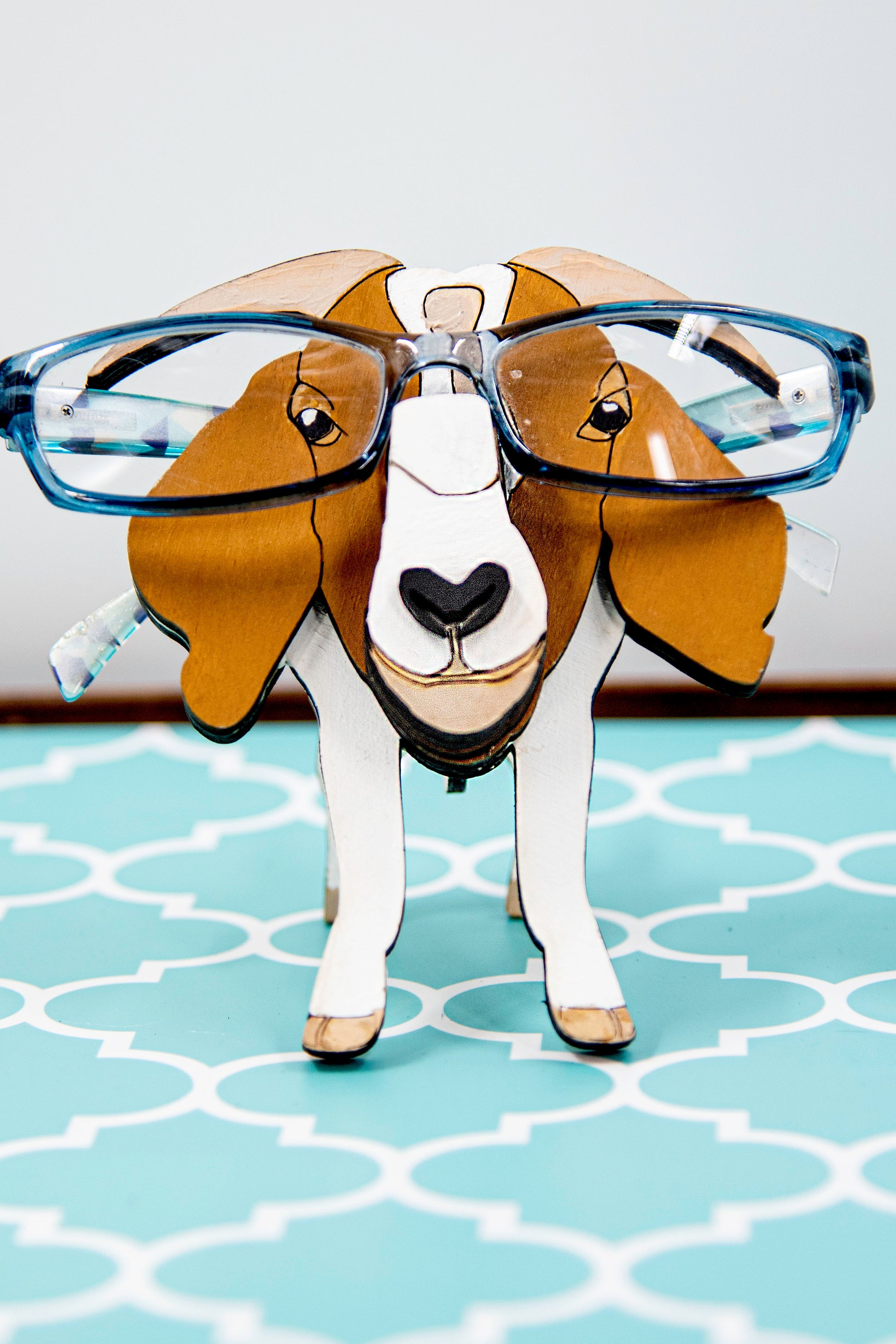 Handcrafted wooden goat glasses holder featuring carved facial details, horns, and a sturdy snout to support eyeglasses. Painted in rustic tones, this charming eyeglass stand is perfect for goat enthusiasts, farmers, or anyone who loves quirky animal decor.