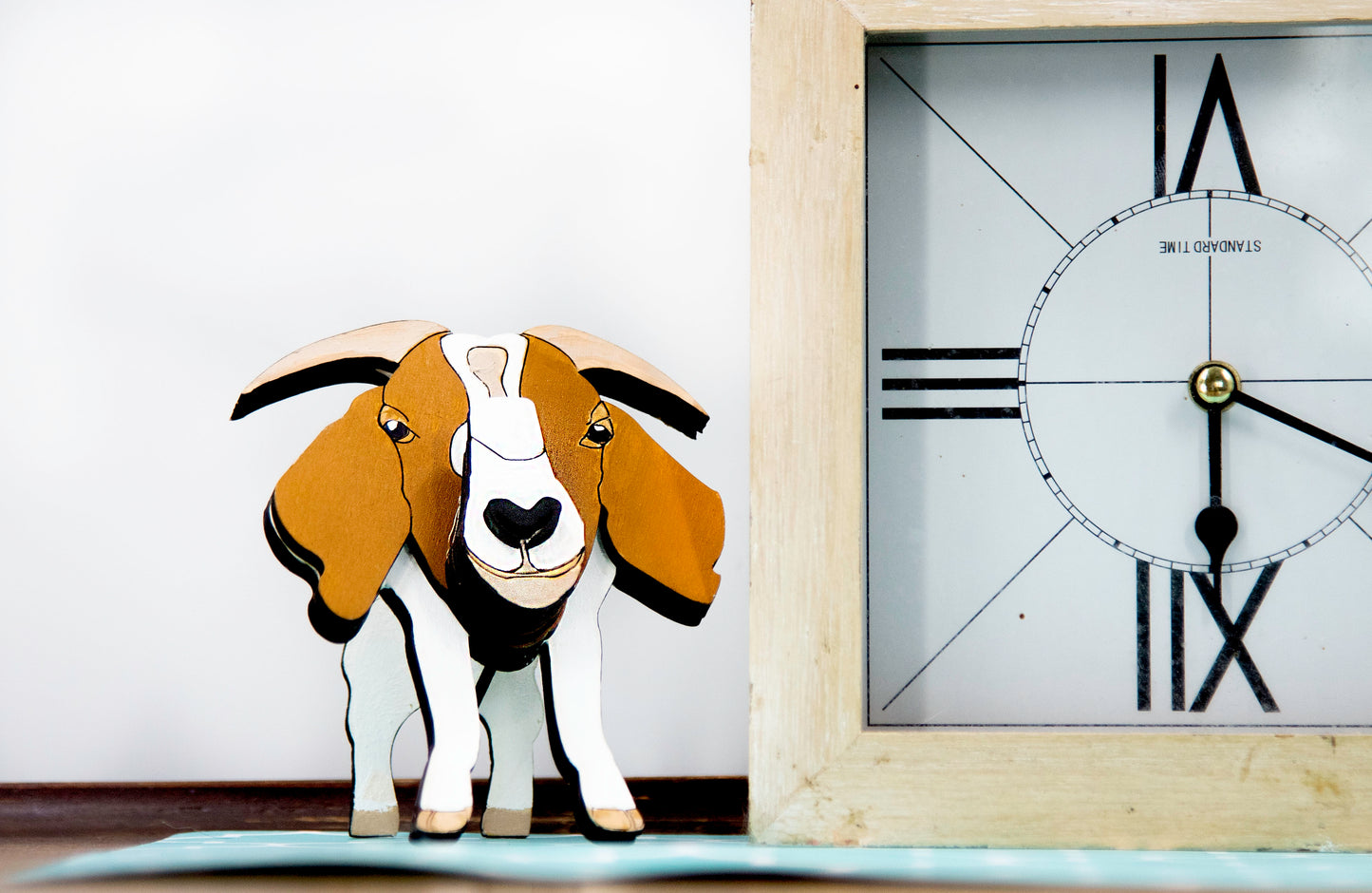 Handcrafted wooden goat glasses holder featuring carved facial details, horns, and a sturdy snout to support eyeglasses. Painted in rustic tones, this charming eyeglass stand is perfect for goat enthusiasts, farmers, or anyone who loves quirky animal decor.