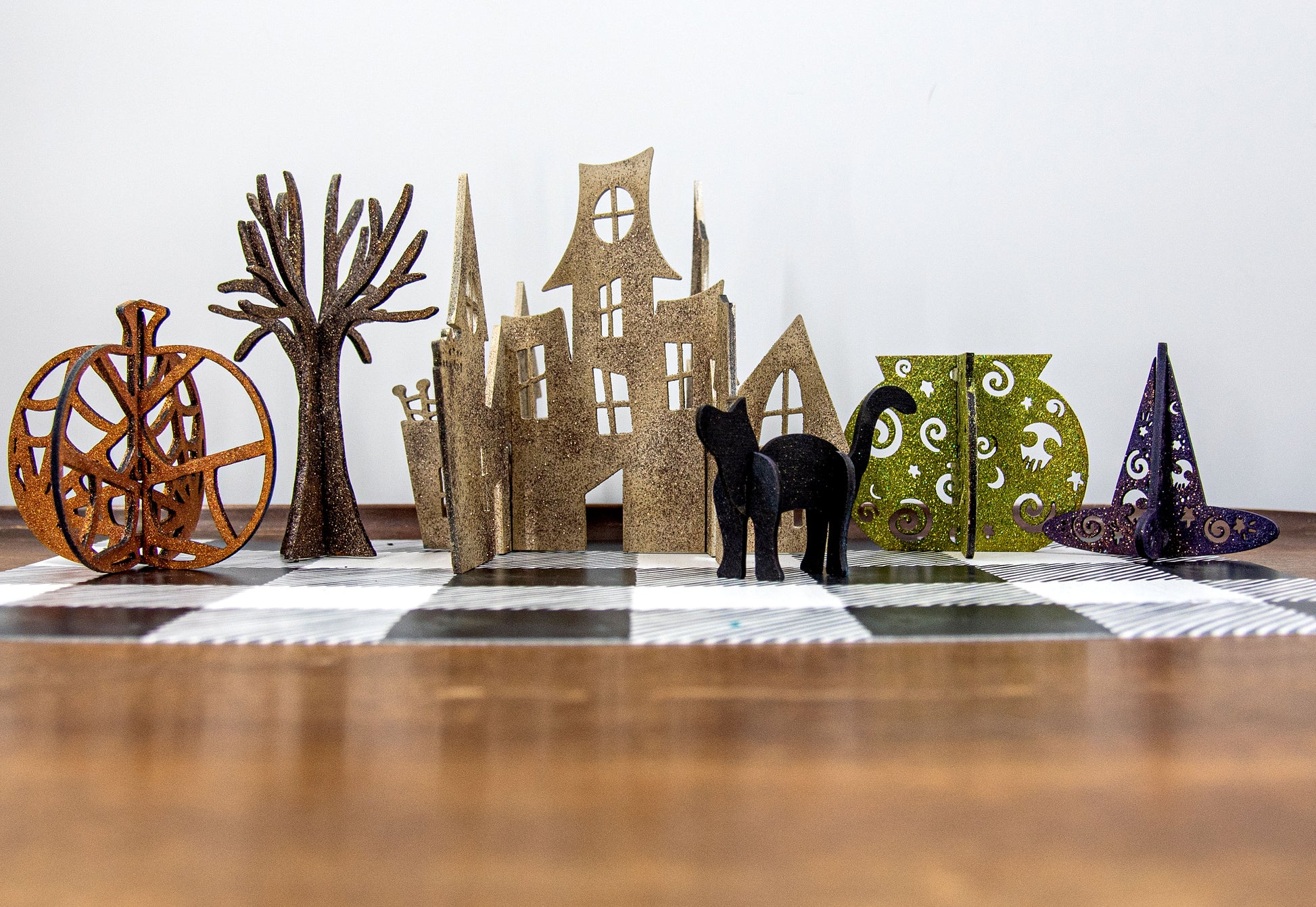 Colorful 3D Halloween shelf sitters made of sliding interlocking wooden pieces, including a pumpkin, haunted house, cat, witch hat, cauldron, and tree. Painted in spooky fall tones from 3 to 7 inches tall.