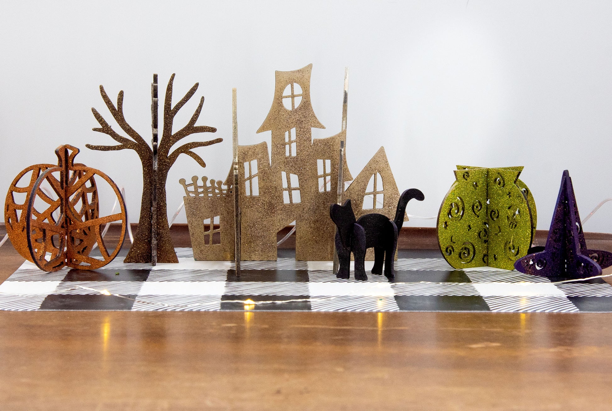 Colorful 3D Halloween shelf sitters made of sliding interlocking wooden pieces, including a pumpkin, haunted house, cat, witch hat, cauldron, and tree. Painted in spooky fall tones from 3 to 7 inches tall.