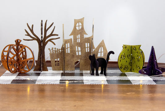 Colorful 3D Halloween shelf sitters made of sliding interlocking wooden pieces, including a pumpkin, haunted house, cat, witch hat, cauldron, and tree. Painted in spooky fall tones from 3 to 7 inches tall.