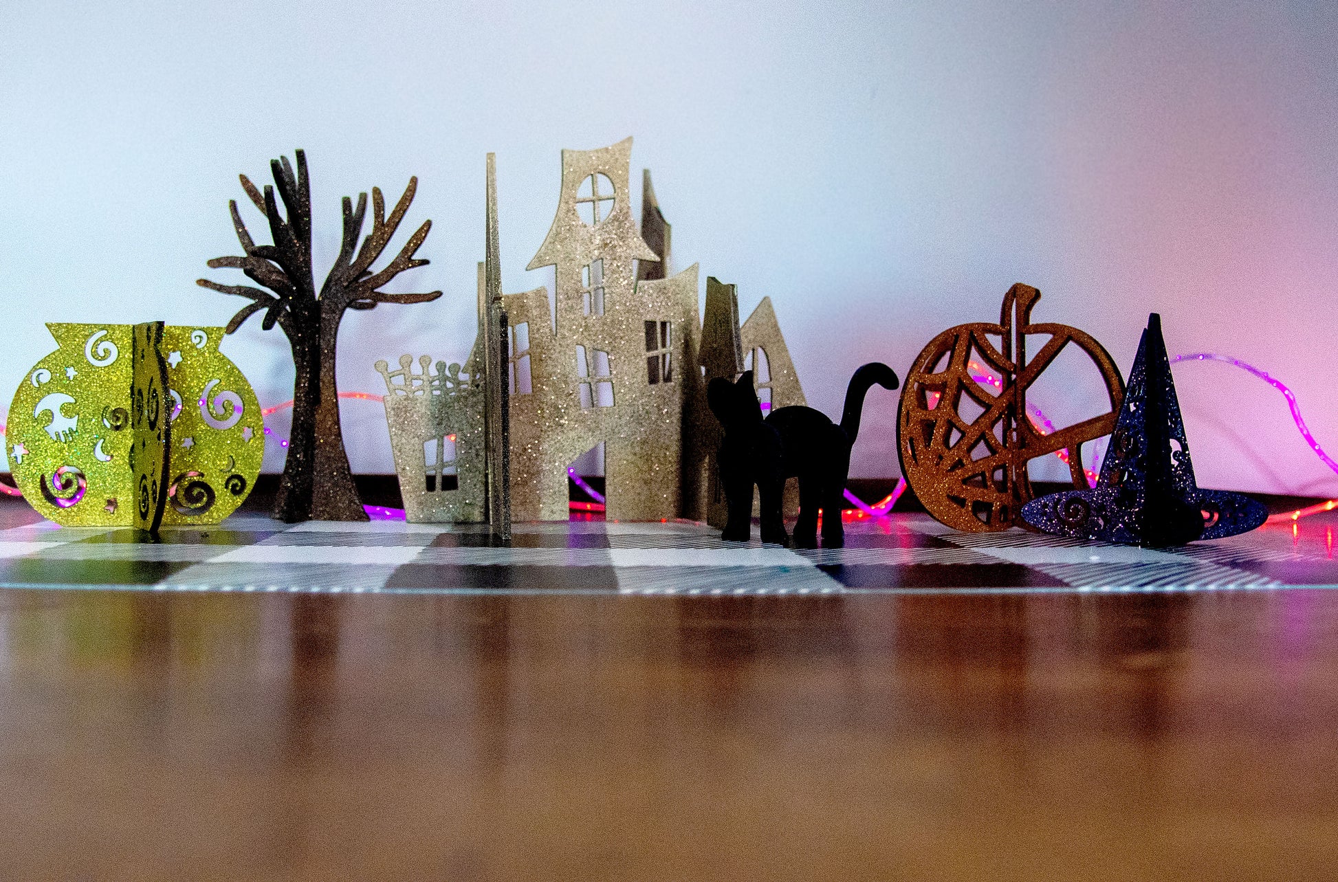 Colorful 3D Halloween shelf sitters made of sliding interlocking wooden pieces, including a pumpkin, haunted house, cat, witch hat, cauldron, and tree. Painted in spooky fall tones from 3 to 7 inches tall.