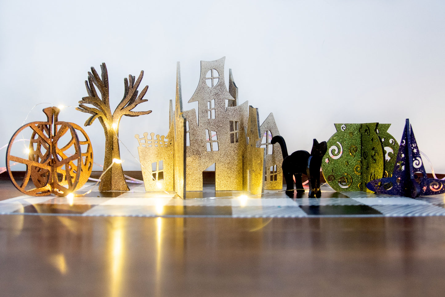 Colorful 3D Halloween shelf sitters made of sliding interlocking wooden pieces, including a pumpkin, haunted house, cat, witch hat, cauldron, and tree. Painted in spooky fall tones from 3 to 7 inches tall.