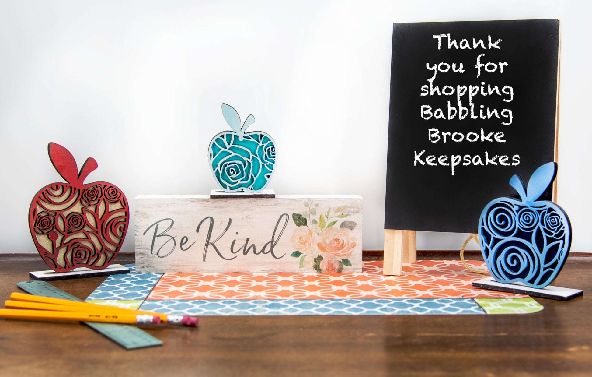 A handcrafted set of three standing wooden apple shelf sitters in assorted fall colors and patterns. These tiered tray-ready decorations include a rustic base and patterned top layer. Available individually or as a complete set, they bring warmth and charm to autumn home decor, classroom displays, or teacher gifts. Sizes range from 3.75" to 5.5".
