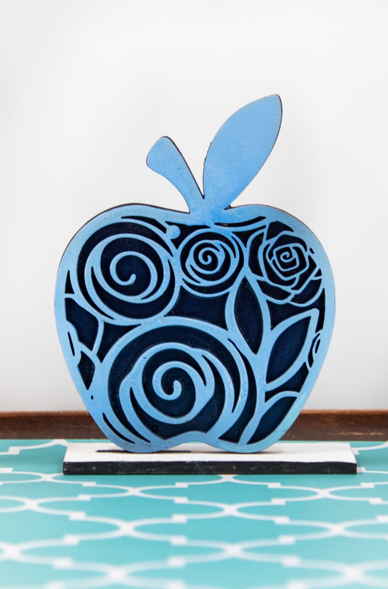 A handcrafted set of three standing wooden apple shelf sitters in assorted fall colors and patterns. These tiered tray-ready decorations include a rustic base and patterned top layer. Available individually or as a complete set, they bring warmth and charm to autumn home decor, classroom displays, or teacher gifts. Sizes range from 3.75" to 5.5".
