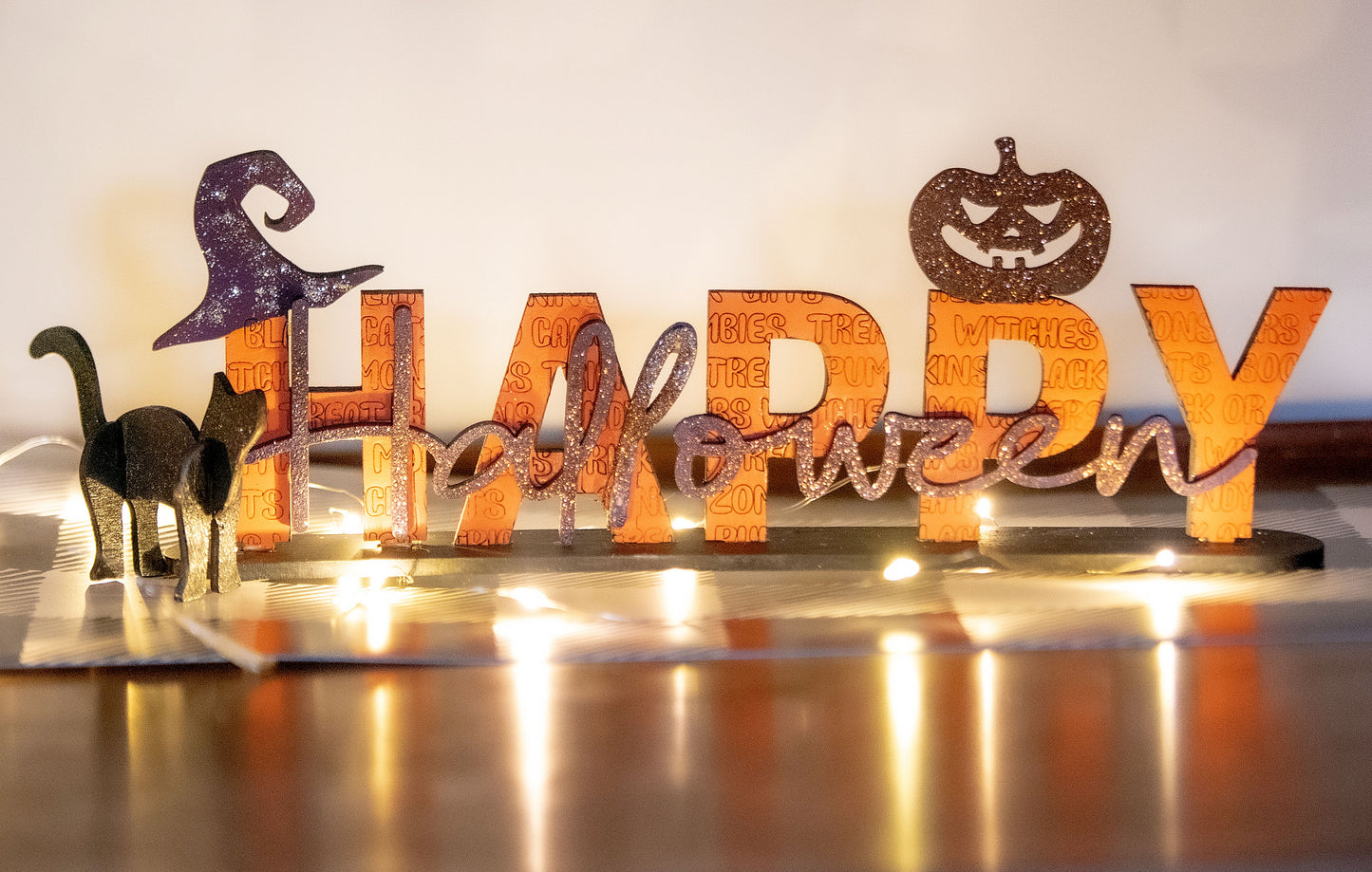 Happy Halloween wooden shelf sitter sign in festive spooky colors, laser-cut layered wood, free-standing design for mantels, shelves, or tiered tray fall decor.
