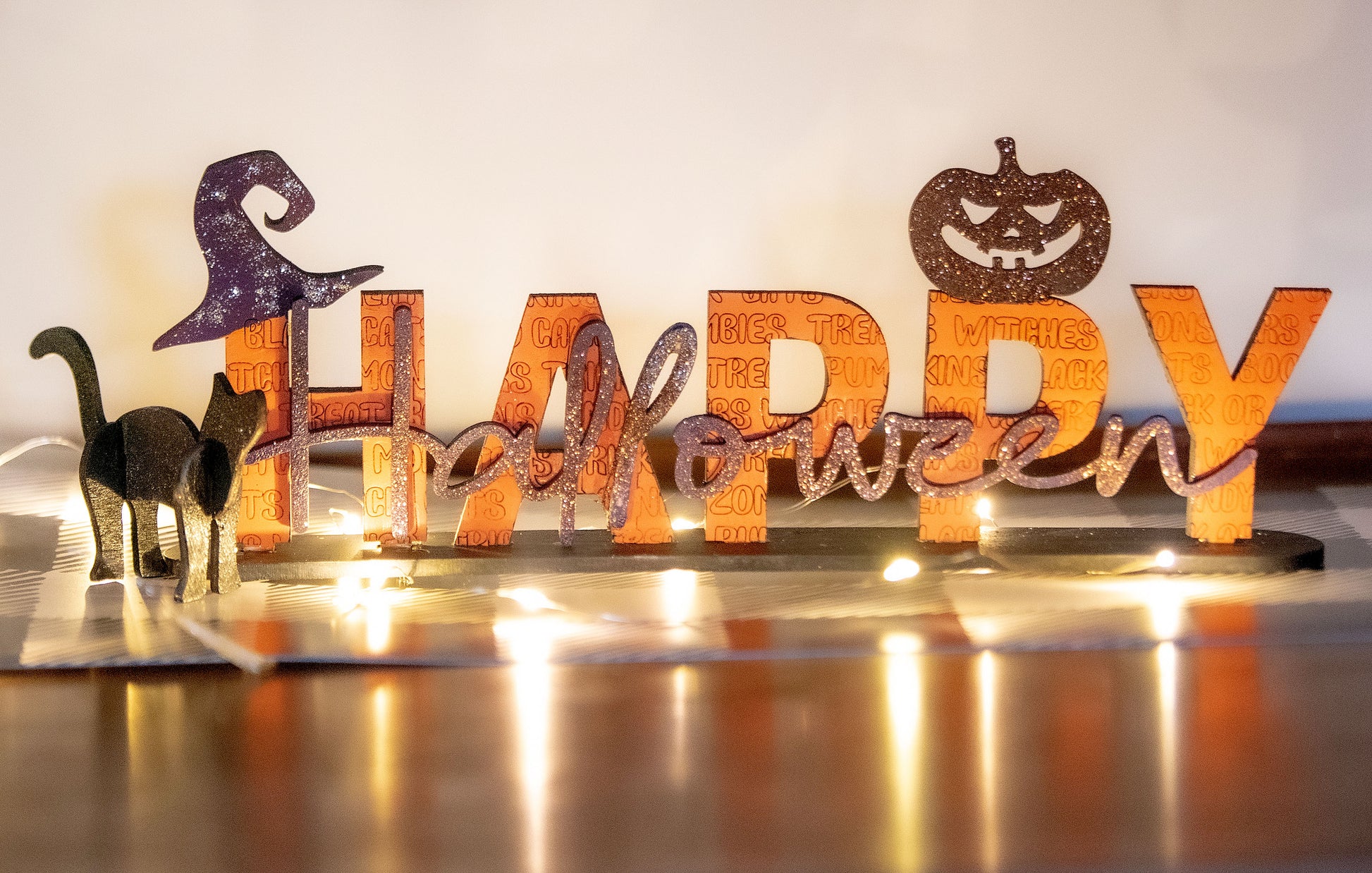 Happy Halloween wooden shelf sitter sign in festive spooky colors, laser-cut layered wood, free-standing design for mantels, shelves, or tiered tray fall decor.
