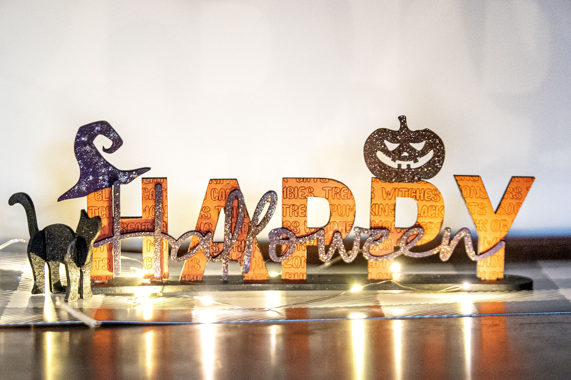 Happy Halloween wooden shelf sitter sign in festive spooky colors, laser-cut layered wood, free-standing design for mantels, shelves, or tiered tray fall decor.
