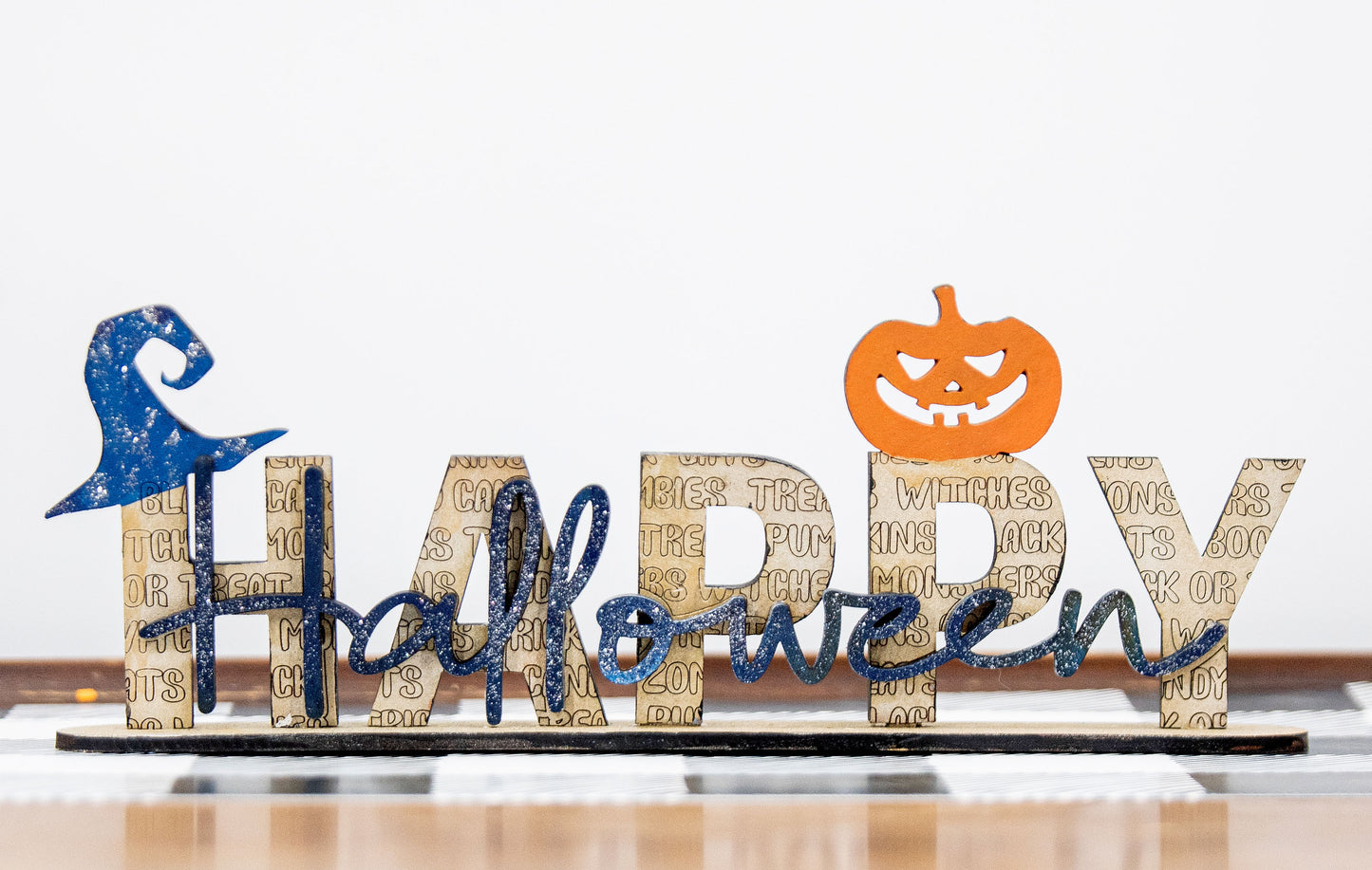 Happy Halloween wooden shelf sitter sign in festive spooky colors, laser-cut layered wood, free-standing design for mantels, shelves, or tiered tray fall decor.
