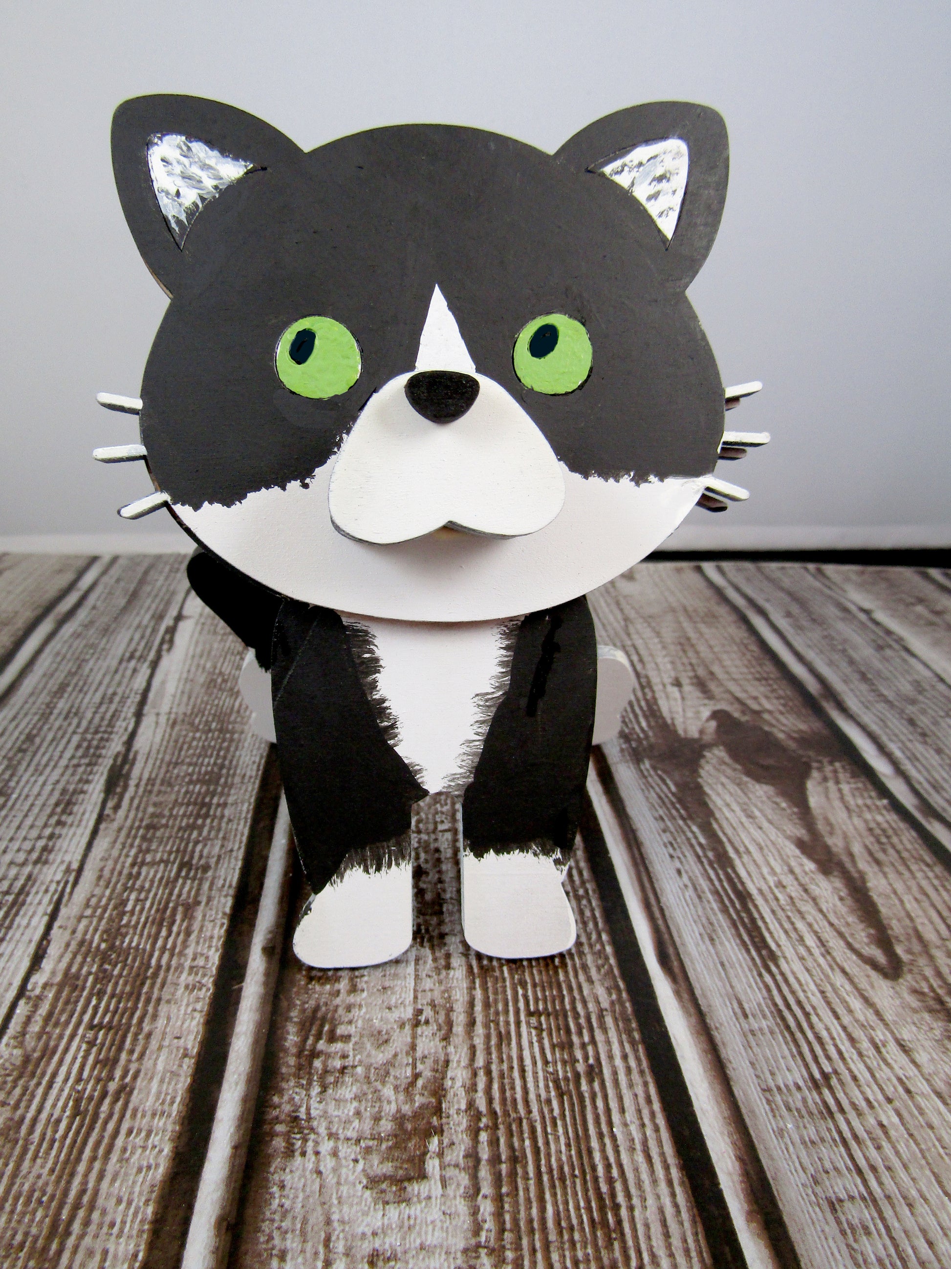 Custom-painted wooden cat glasses holder shaped like a sitting cat with eyeglasses resting on its nose. Available in black, white, orange, gray, tabby, Siamese, tuxedo, or painted from your cat's photo with optional name personalization.