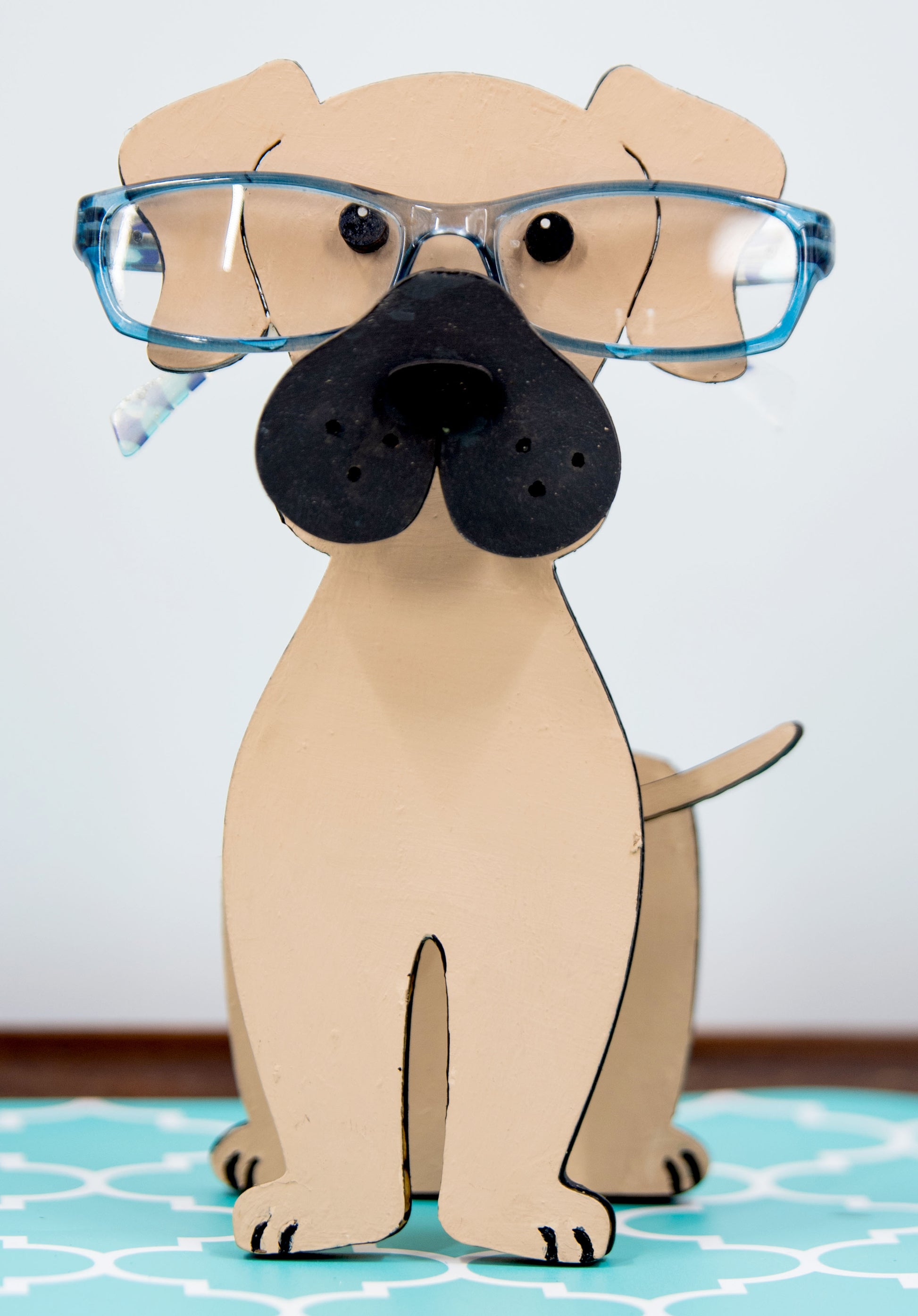 Handmade wooden glasses holder shaped like a Mastiff dog, featuring carved facial details and a sturdy snout that securely holds eyeglasses. Finished in rustic tones with optional personalization, this stand is perfect for Mastiff lovers and adds charm and function to any desk, nightstand, or shelf.
