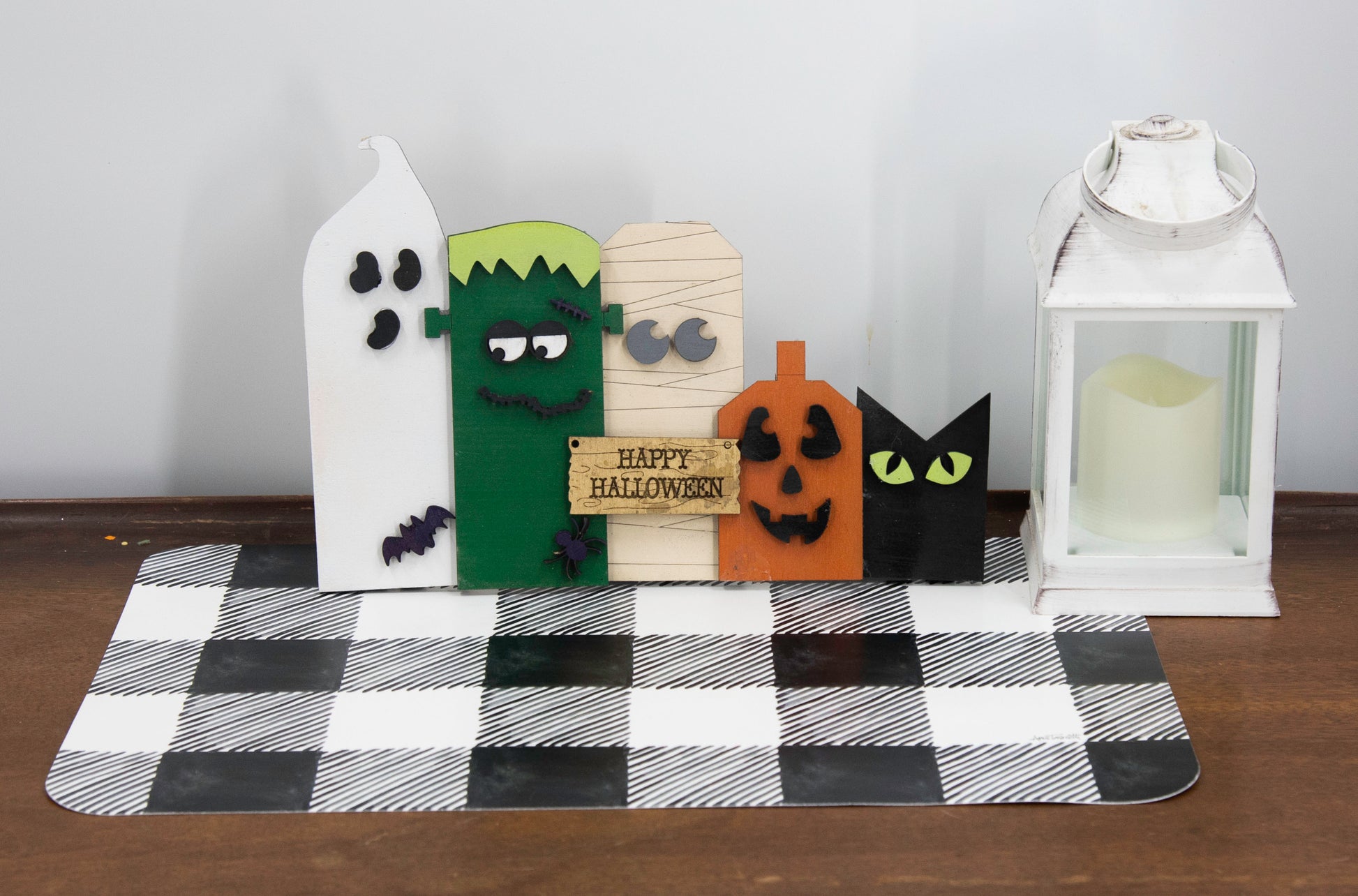 Layered wooden Halloween character shelf sitter set featuring Frankenstein, ghost, black cat, pumpkin, and tombstone. Includes interchangeable face designs, personalized sign text, and multiple size options for Halloween home decor.