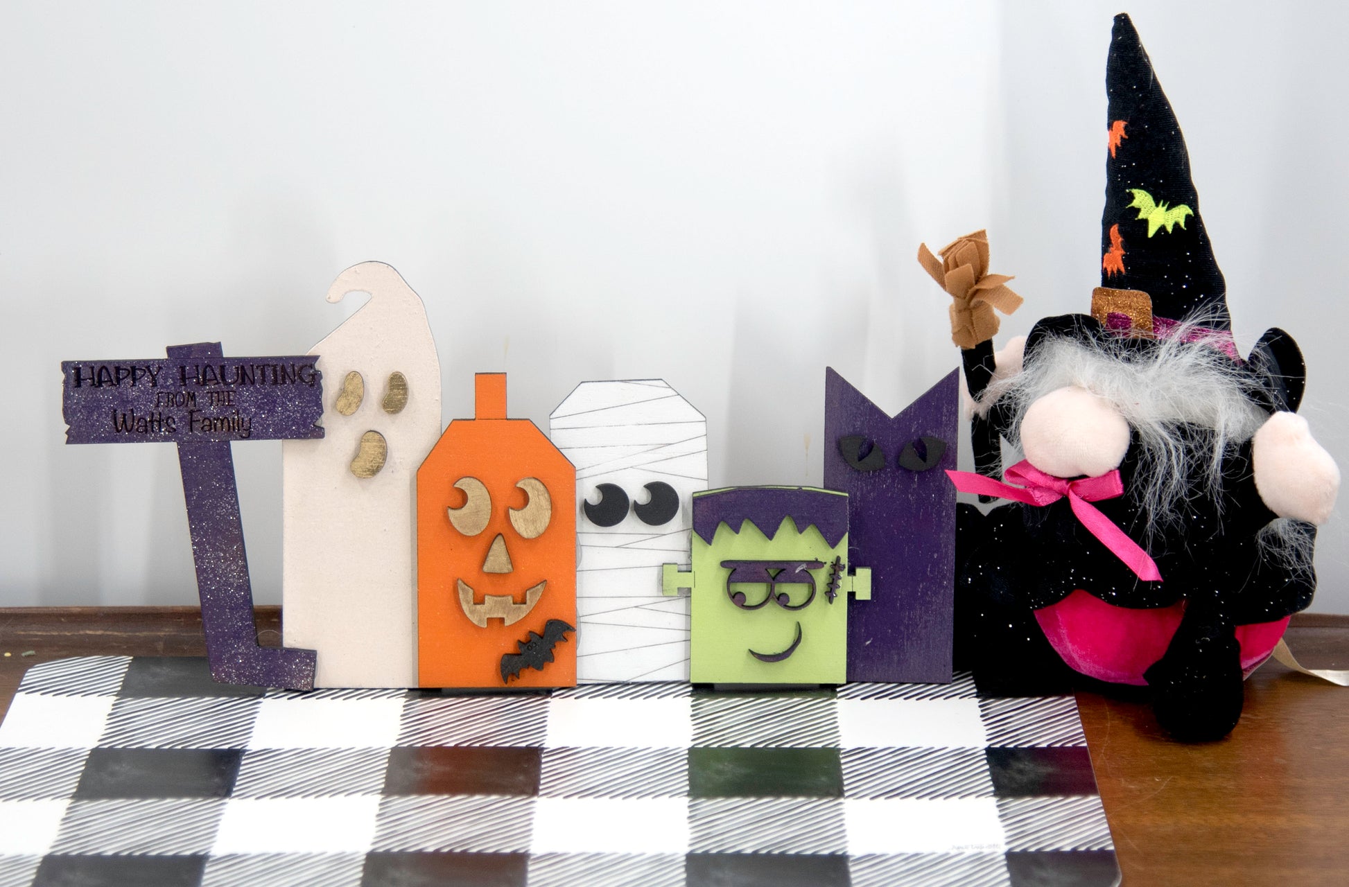 Layered wooden Halloween character shelf sitter set featuring Frankenstein, ghost, black cat, pumpkin, and tombstone. Includes interchangeable face designs, personalized sign text, and multiple size options for Halloween home decor.
