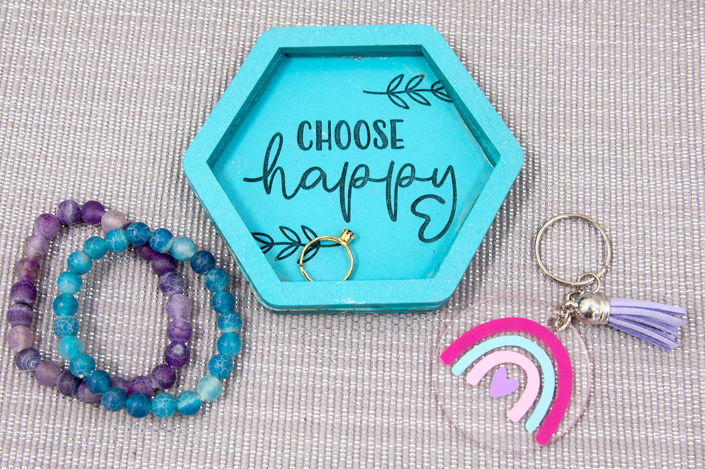 Set of small 3.75-inch round wooden trinket dishes available in various bright colors, each engraved with playful or inspiring sayings like 'Choose Happy,' 'Shit I Can’t Lose,' and 'Collect Moments Not Things.' These colorful dishes work perfectly as jewelry holders, desk catch-alls, or thoughtful gifts