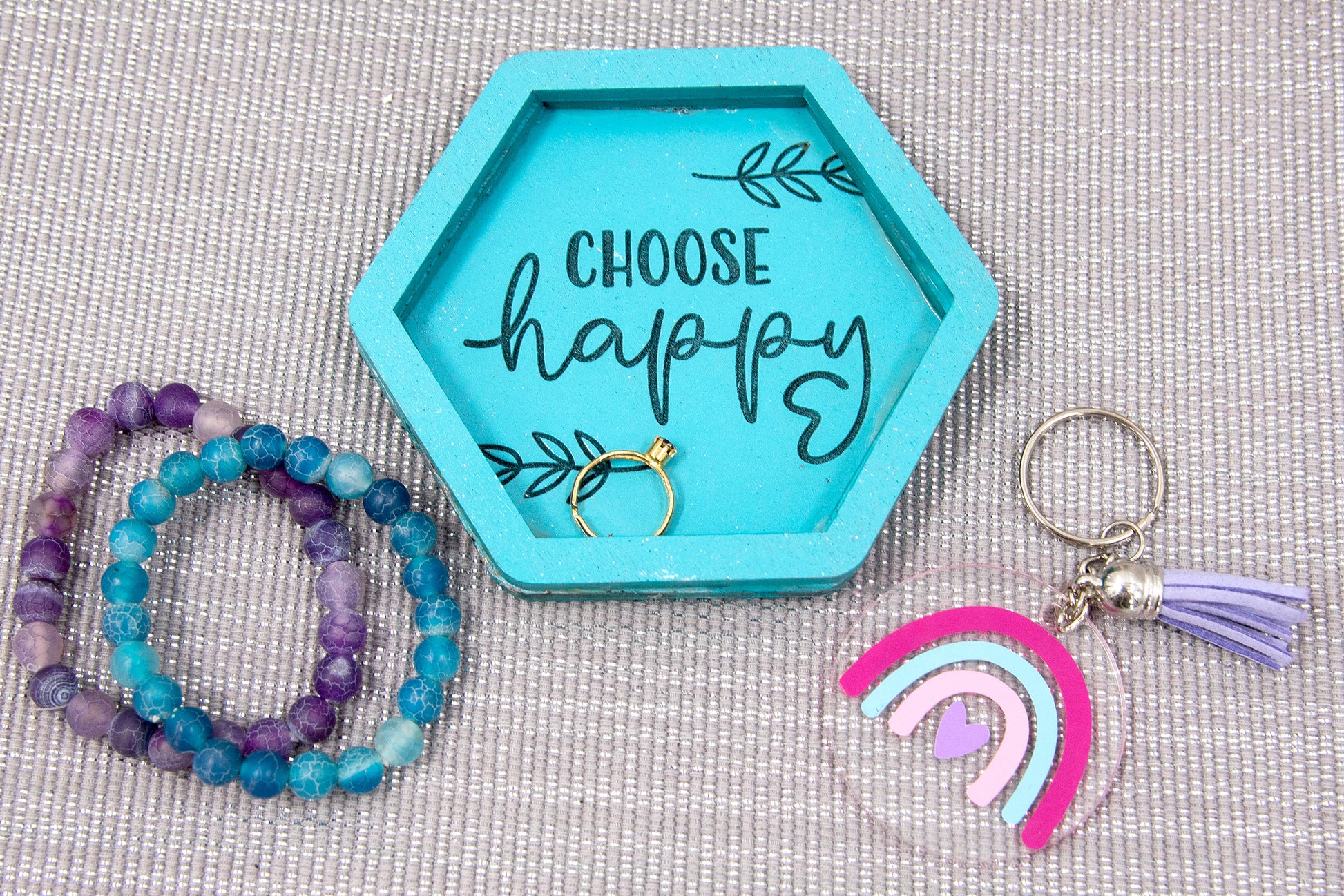 Set of small 3.75-inch round wooden trinket dishes available in various bright colors, each engraved with playful or inspiring sayings like 'Choose Happy,' 'Shit I Can’t Lose,' and 'Collect Moments Not Things.' These colorful dishes work perfectly as jewelry holders, desk catch-alls, or thoughtful gifts