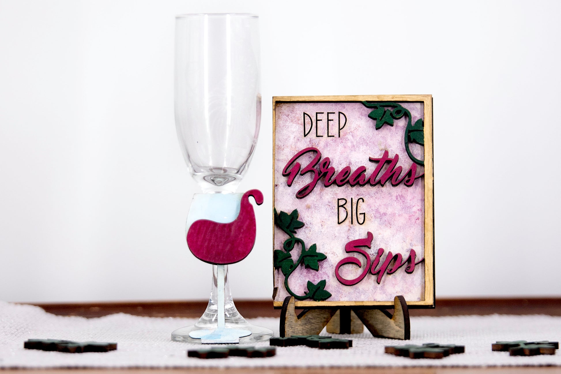 A 6-piece wine-themed wooden tiered tray set featuring humorous mom quotes like "They whine, I wine" and "Mommy juice," painted in maroon, grey, gold, and light grey with included stands and optional tiered tray
