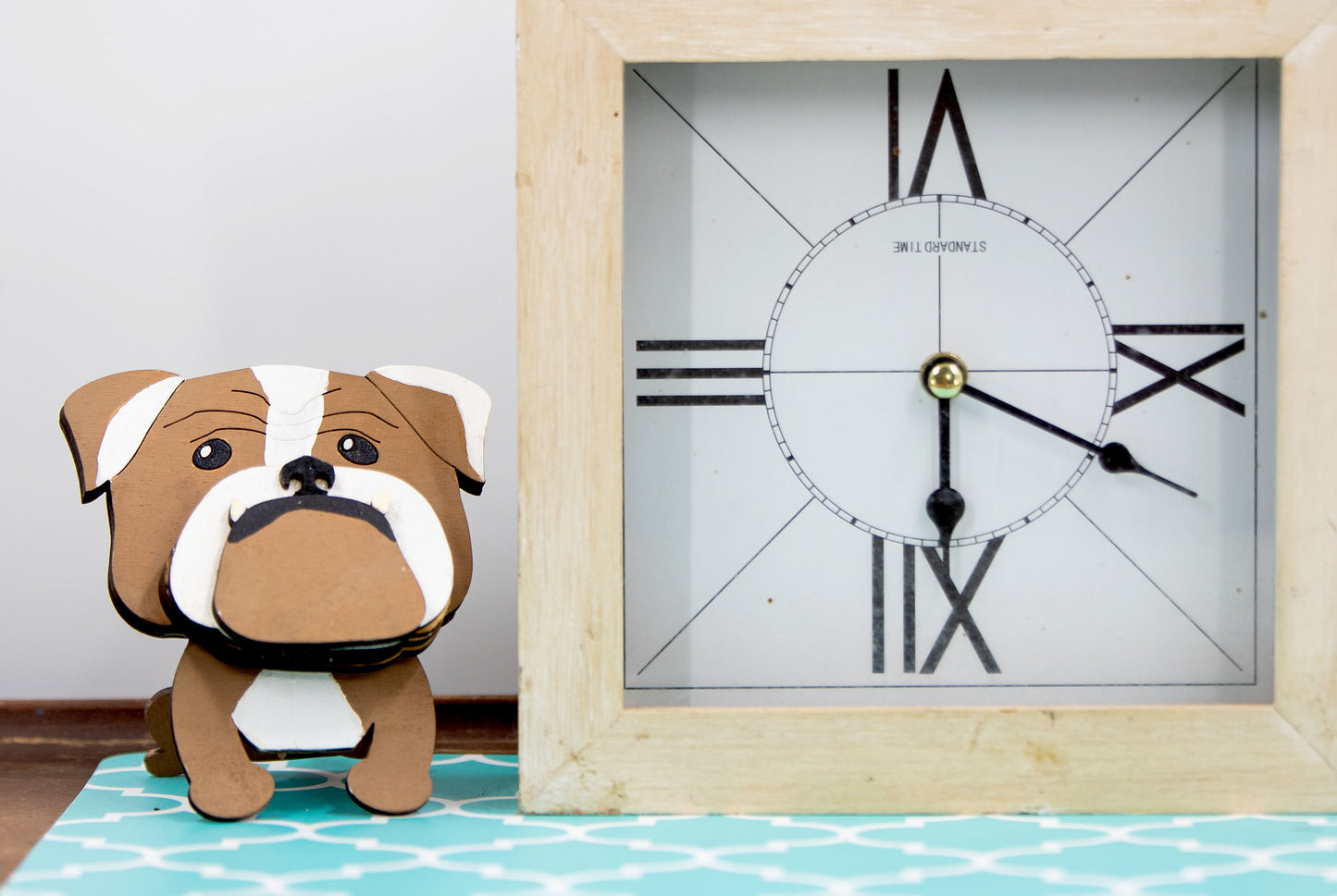 A hand-painted wooden glasses stand shaped like the face of an English Bulldog, featuring the breed’s signature wrinkled face and droopy cheeks. Designed with a flat base for stability, the stand holds eyeglasses securely on the Bulldog’s nose, making it a functional and charming decor piece for desks, nightstands, or shelves.