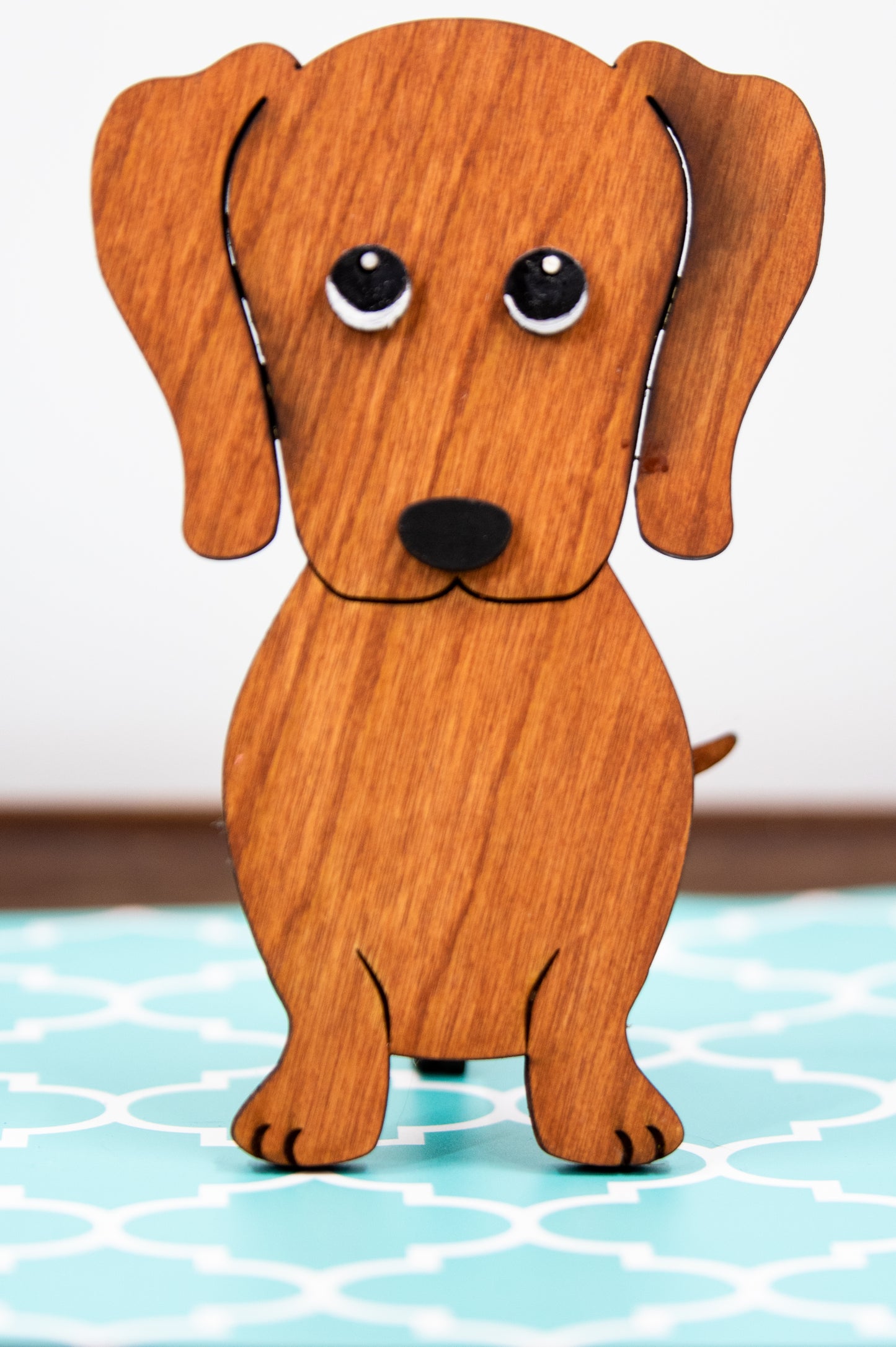Large stained dachshund glasses holder made from solid wood, shown in red/brown finish, designed to keep eyeglasses secure while adding charm to your decor. Handmade eyeglass stand shaped like a dachshund with adorable detailing, perfect for bedside tables, desks, or as a thoughtful gift for dog lovers. Available in red/brown, black, or custom stain colors to match your style.
