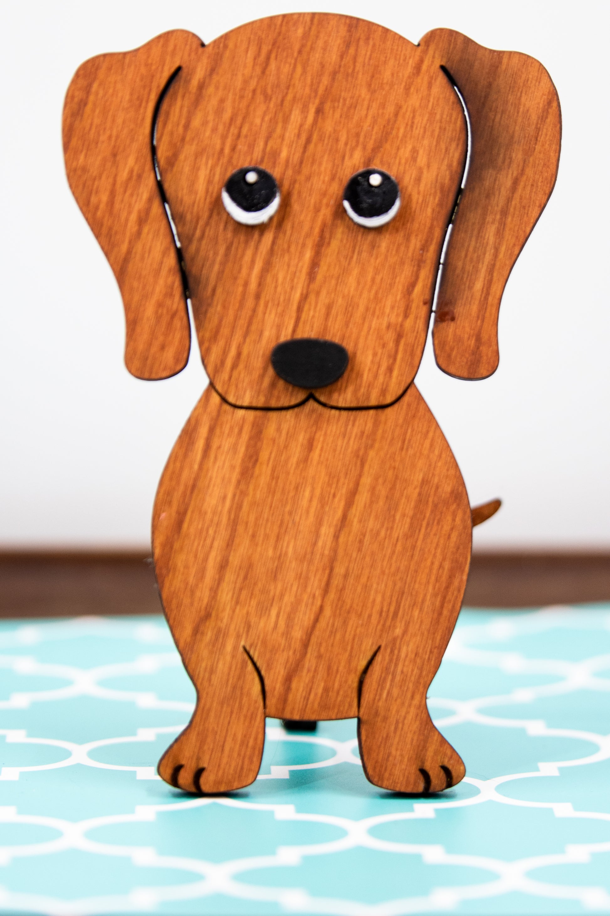 Large stained dachshund glasses holder made from solid wood, shown in red/brown finish, designed to keep eyeglasses secure while adding charm to your decor. Handmade eyeglass stand shaped like a dachshund with adorable detailing, perfect for bedside tables, desks, or as a thoughtful gift for dog lovers. Available in red/brown, black, or custom stain colors to match your style.