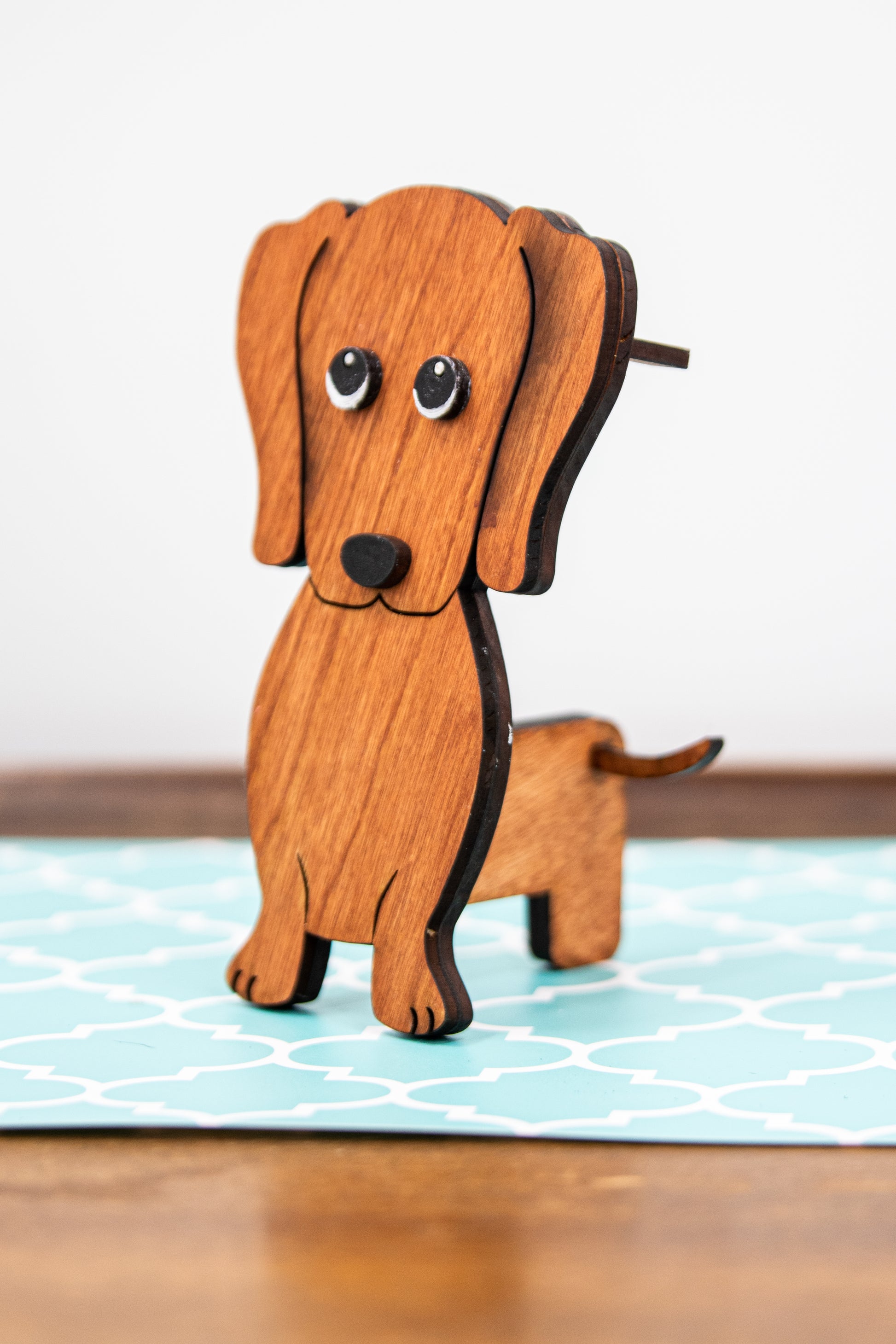 Large stained dachshund glasses holder made from solid wood, shown in red/brown finish, designed to keep eyeglasses secure while adding charm to your decor. Handmade eyeglass stand shaped like a dachshund with adorable detailing, perfect for bedside tables, desks, or as a thoughtful gift for dog lovers. Available in red/brown, black, or custom stain colors to match your style.