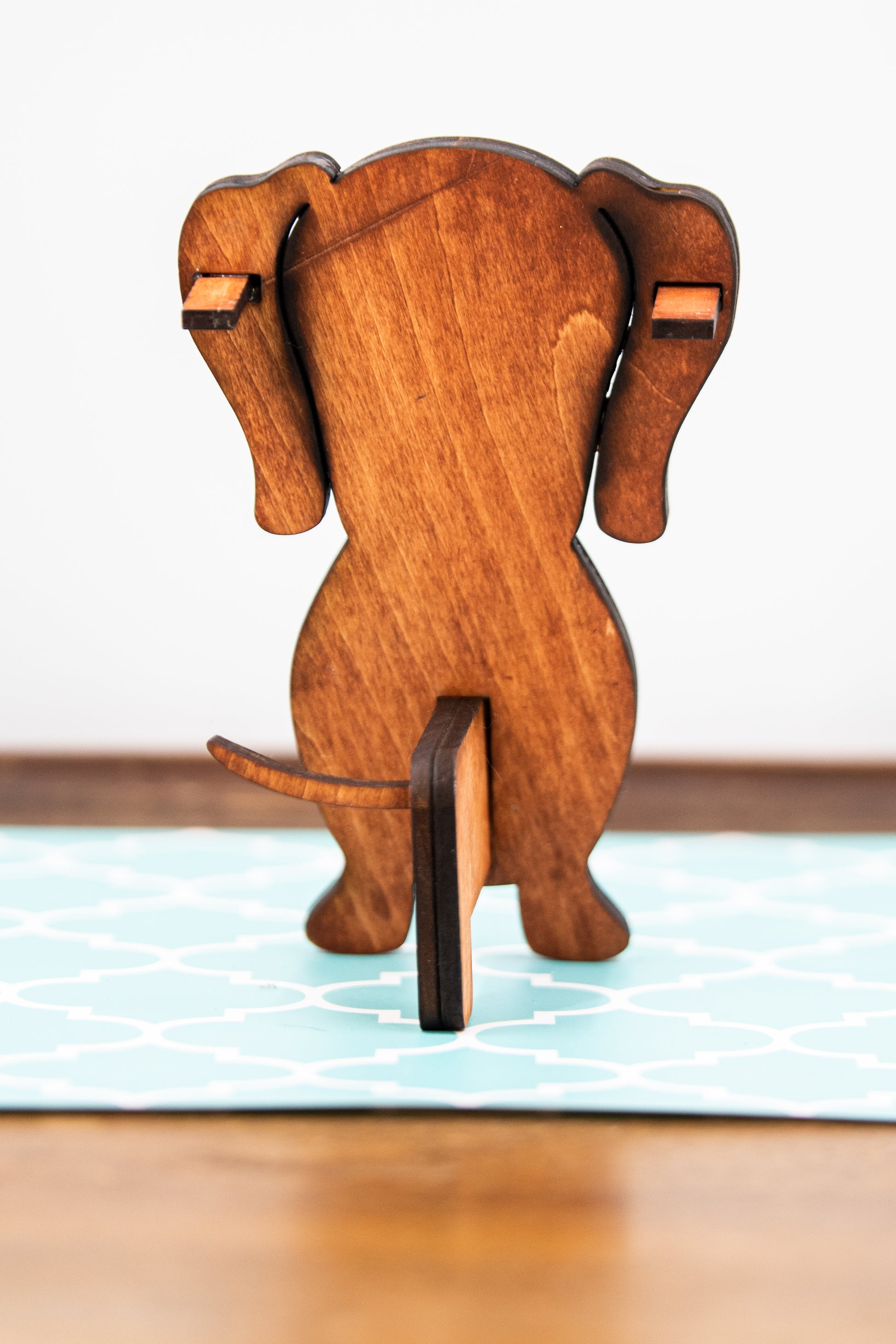 Large stained dachshund glasses holder made from solid wood, shown in red/brown finish, designed to keep eyeglasses secure while adding charm to your decor. Handmade eyeglass stand shaped like a dachshund with adorable detailing, perfect for bedside tables, desks, or as a thoughtful gift for dog lovers. Available in red/brown, black, or custom stain colors to match your style.