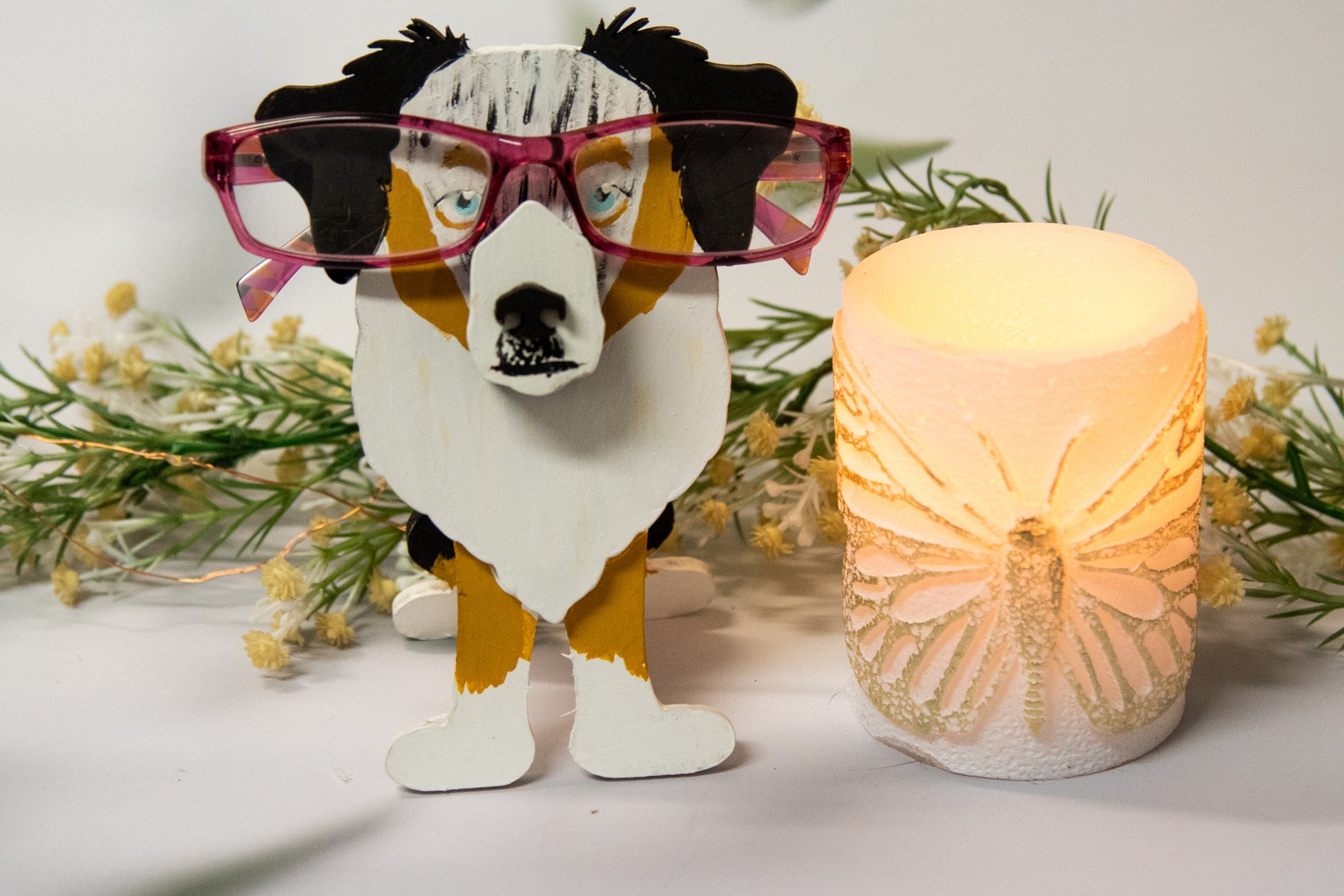 Hand-painted Australian Shepherd eyeglass holder in a sitting dog shape, available in Blue Merle, Red Merle, Black Tri, or custom colors with realistic details, designed to hold glasses on the snout. Cute and functional dog lover gift, hand-crafted and great for desks or nightstands.