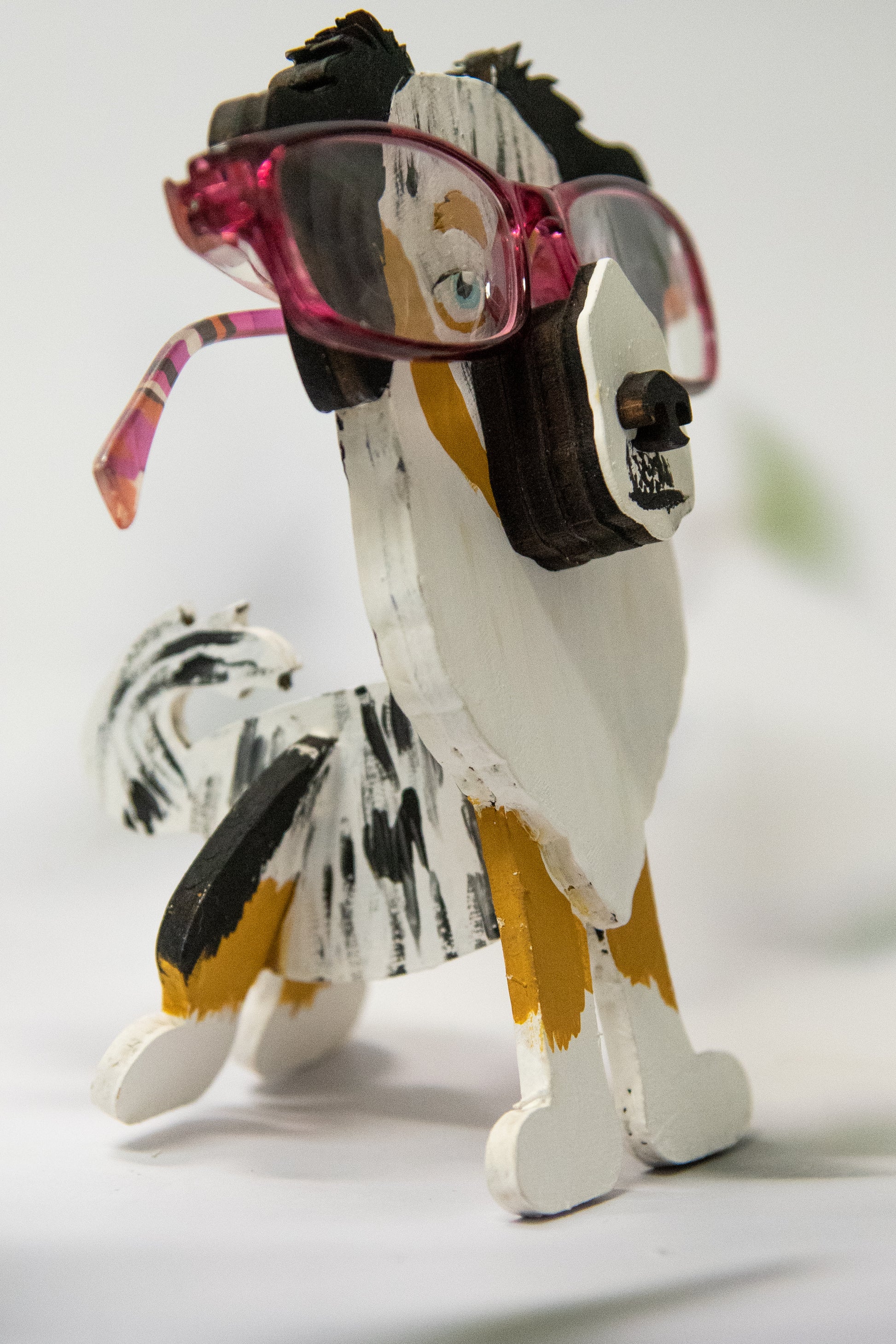 Hand-painted Australian Shepherd eyeglass holder in a sitting dog shape, available in Blue Merle, Red Merle, Black Tri, or custom colors with realistic details, designed to hold glasses on the snout. Cute and functional dog lover gift, hand-crafted and great for desks or nightstands.