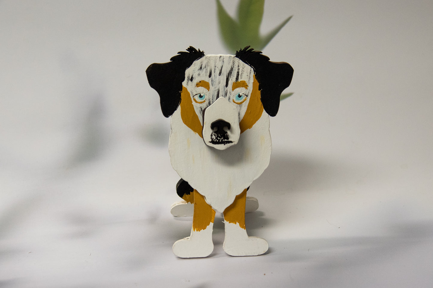 Hand-painted Australian Shepherd eyeglass holder in a sitting dog shape, available in Blue Merle, Red Merle, Black Tri, or custom colors with realistic details, designed to hold glasses on the snout. Cute and functional dog lover gift, hand-crafted and great for desks or nightstands.